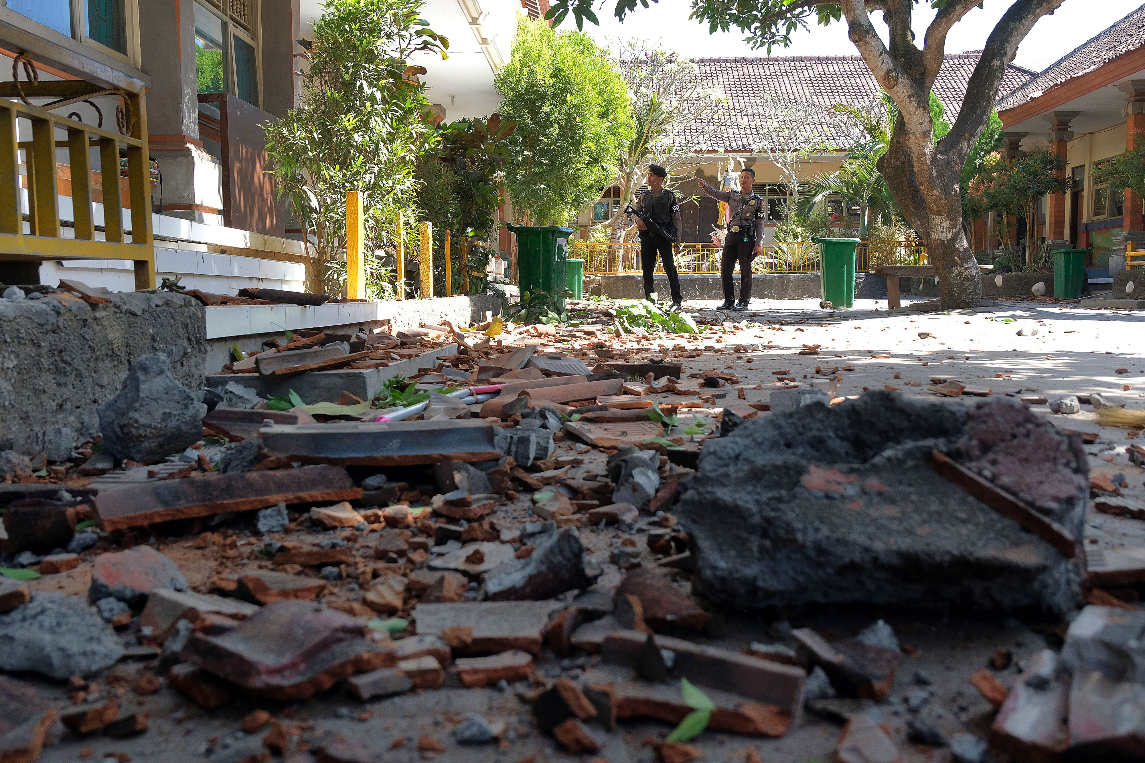  Polisi melihat kondisi bangunan SD No. 1 Ungasan yang rusak di bagian atap akibat gempa bumi di Badung, Bali