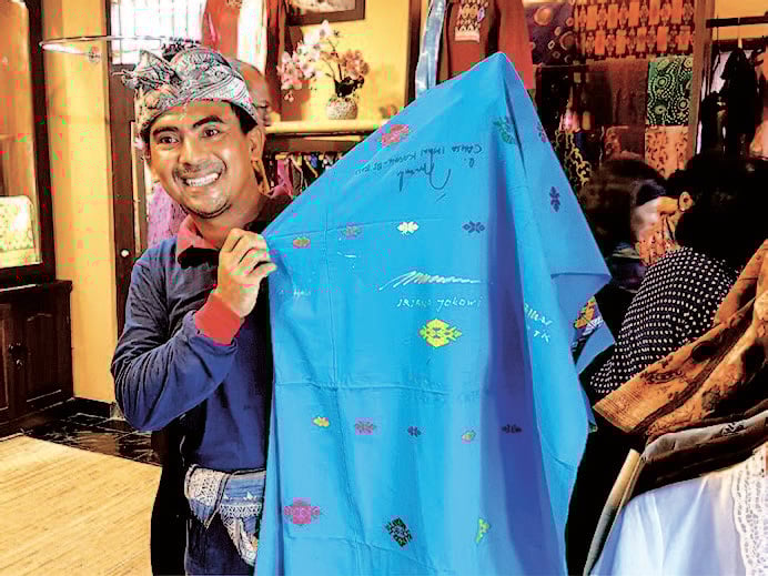 I Ketut Widiadnyana menunjukkan selembar songket yang dipenuhi goresan tanda tangan tokoh nasional