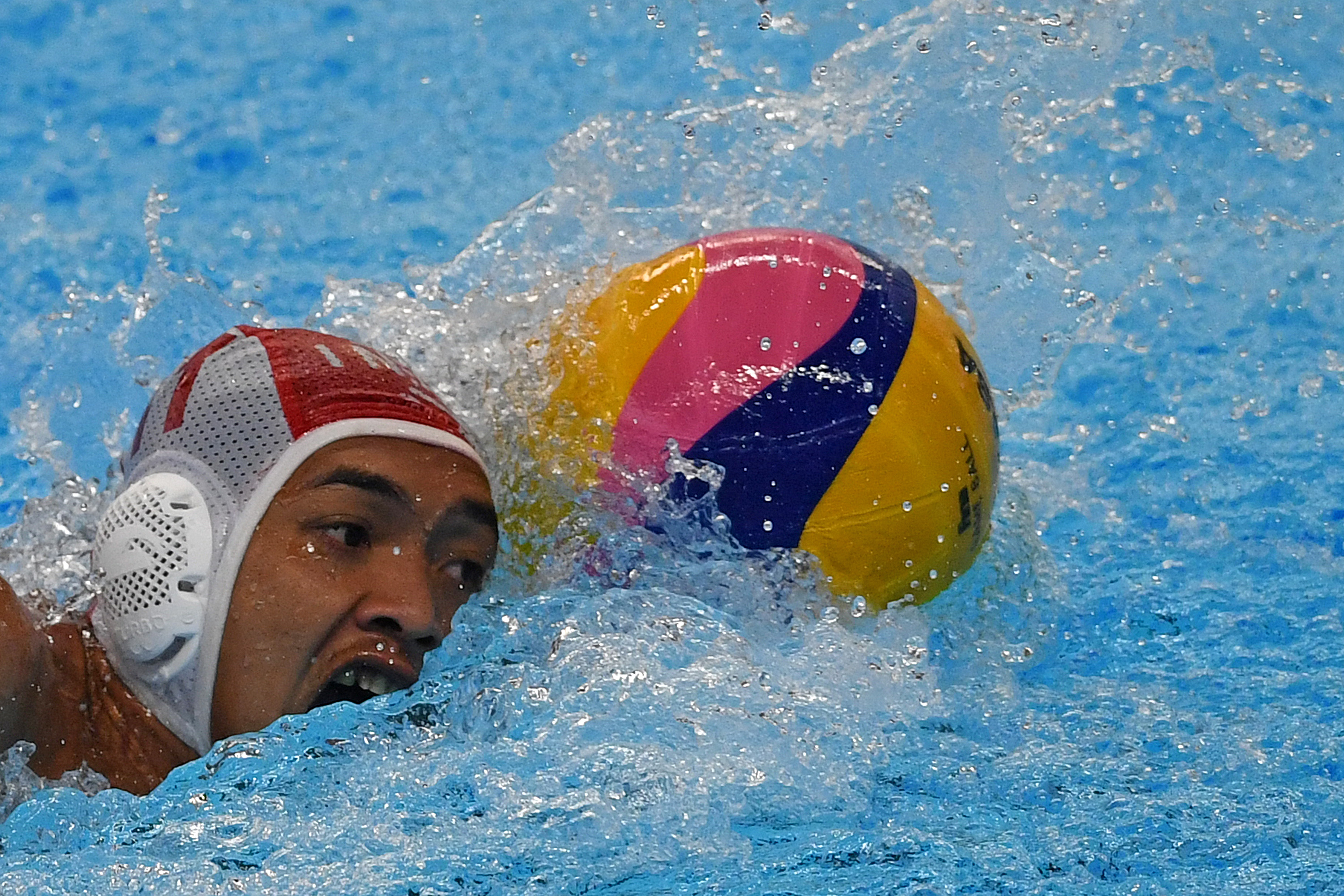 Pemain Polo Air Indonesia Rian Rinaldo menggiring bola ke pertahanan Timnas Jepang pada penyisihan Polo Air Putra Asian Games ke-18