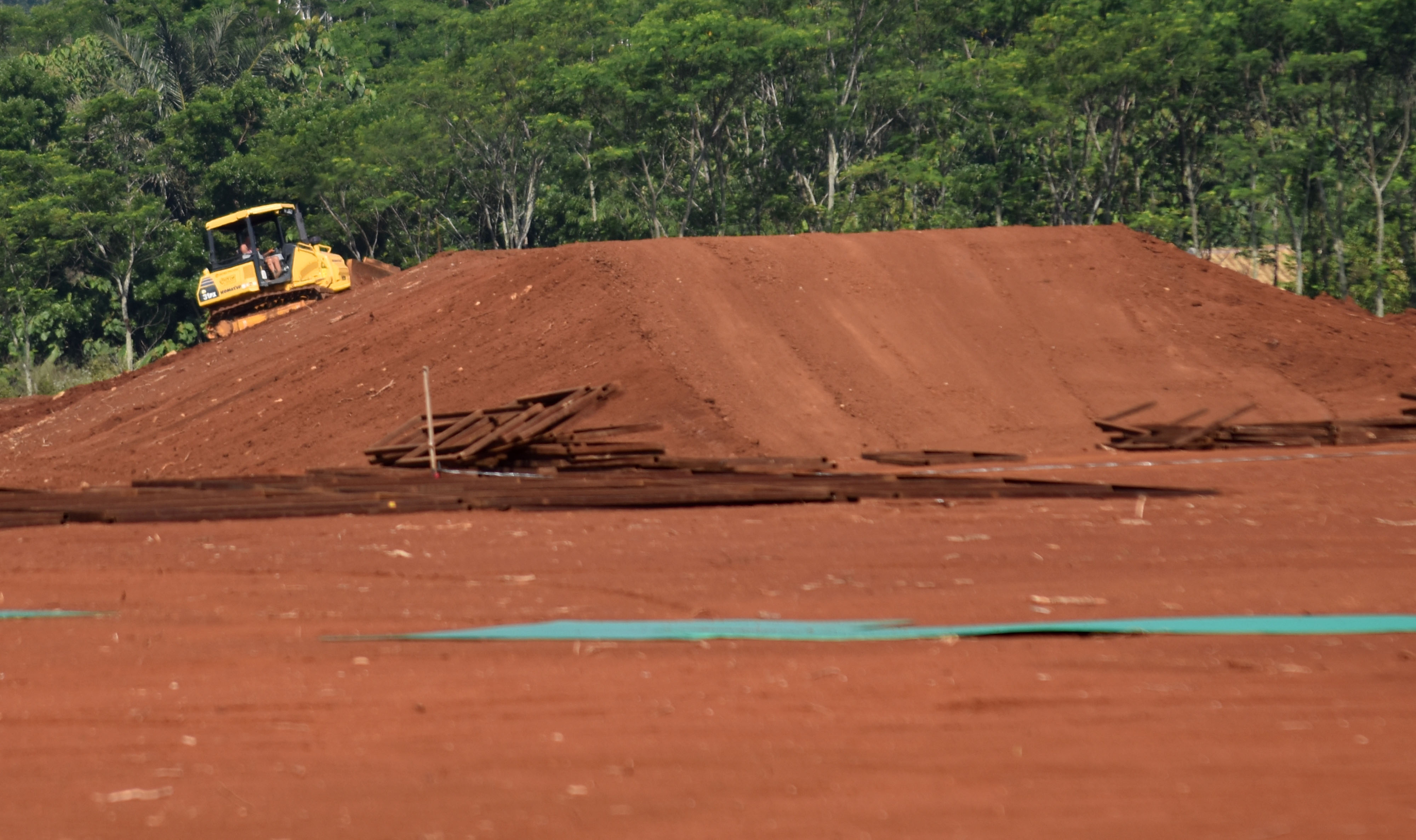Pekerja mengoperasikan alat berat pembangunan sirkuit kompetisi balap motorcross internasional MXGP seri ke-13 di Sirkuit BSB Mijen
