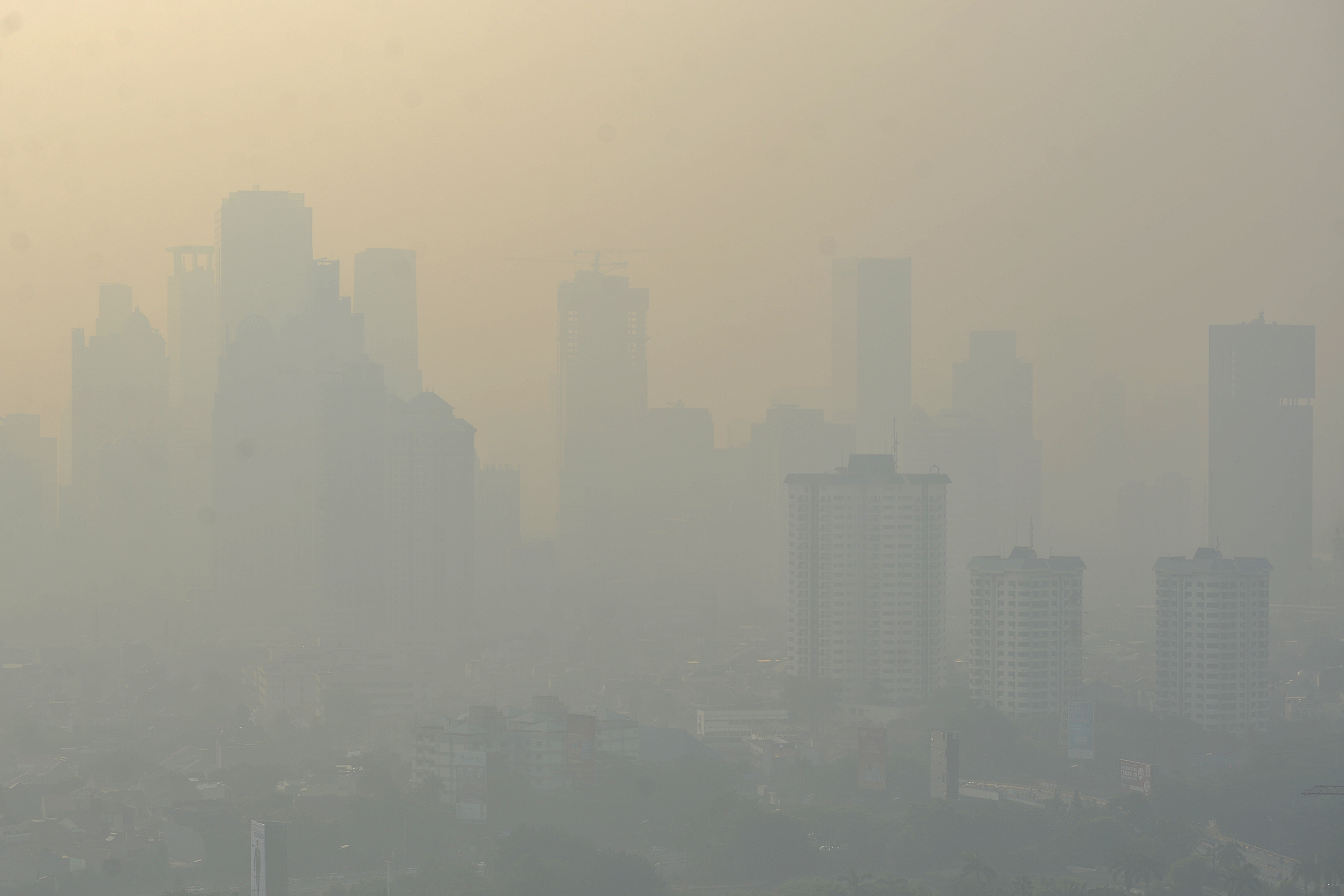 Kabut pekat polusi udara menutupi gedung-gedung tinggi perkantoran di Jakarta.