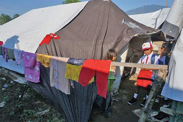 Siswa sekolah dasar (SD) bersiap menuju sekolah pada hari pertama masuk sekolah di Kamp Pengungsian Jono Oge, Kabupaten Sigi, Sulawesi Tenga