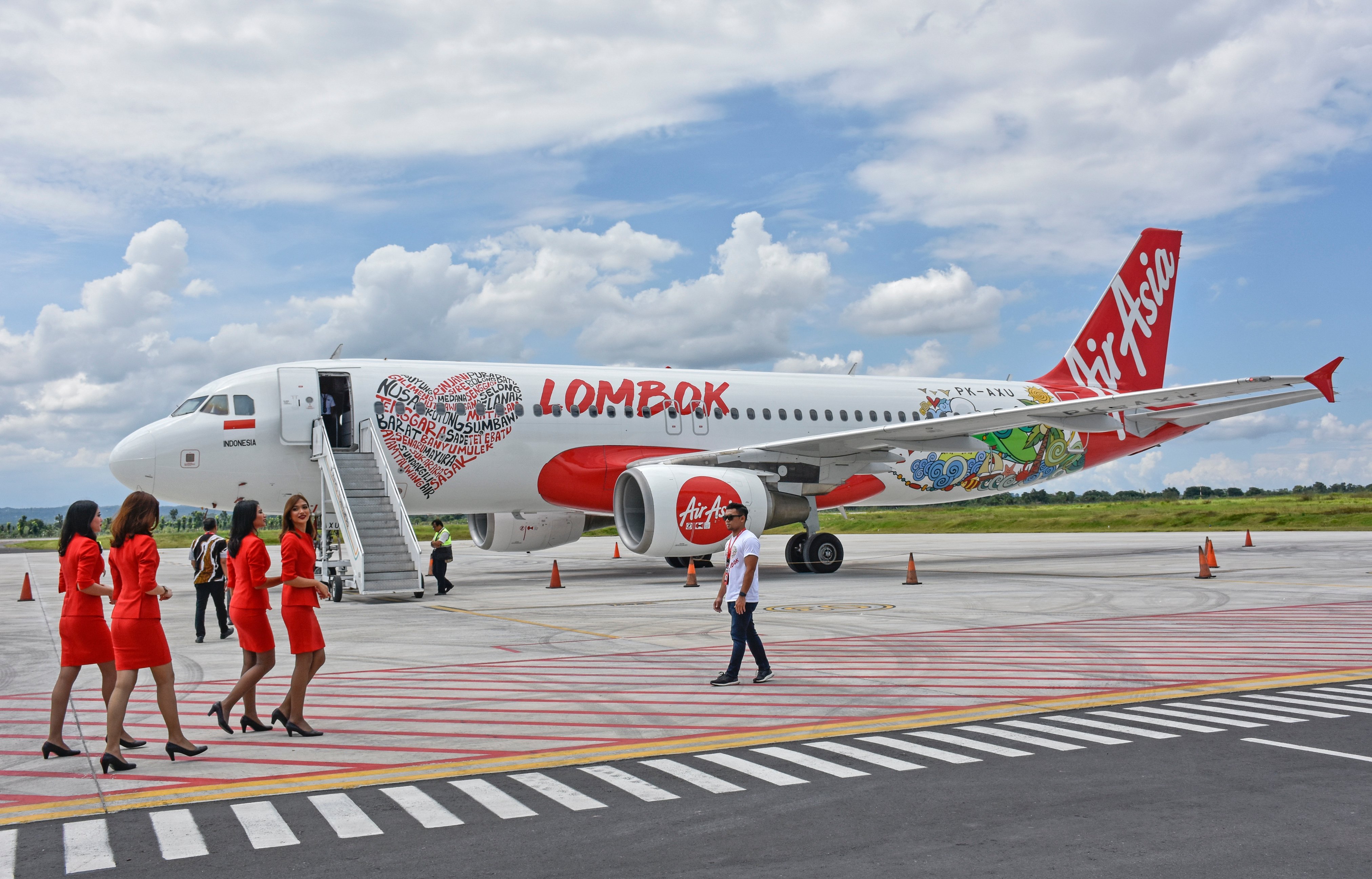 Sejumlah pramugari melintas dekat pesawat AirAsia dengan desain bertemakan Lombok.