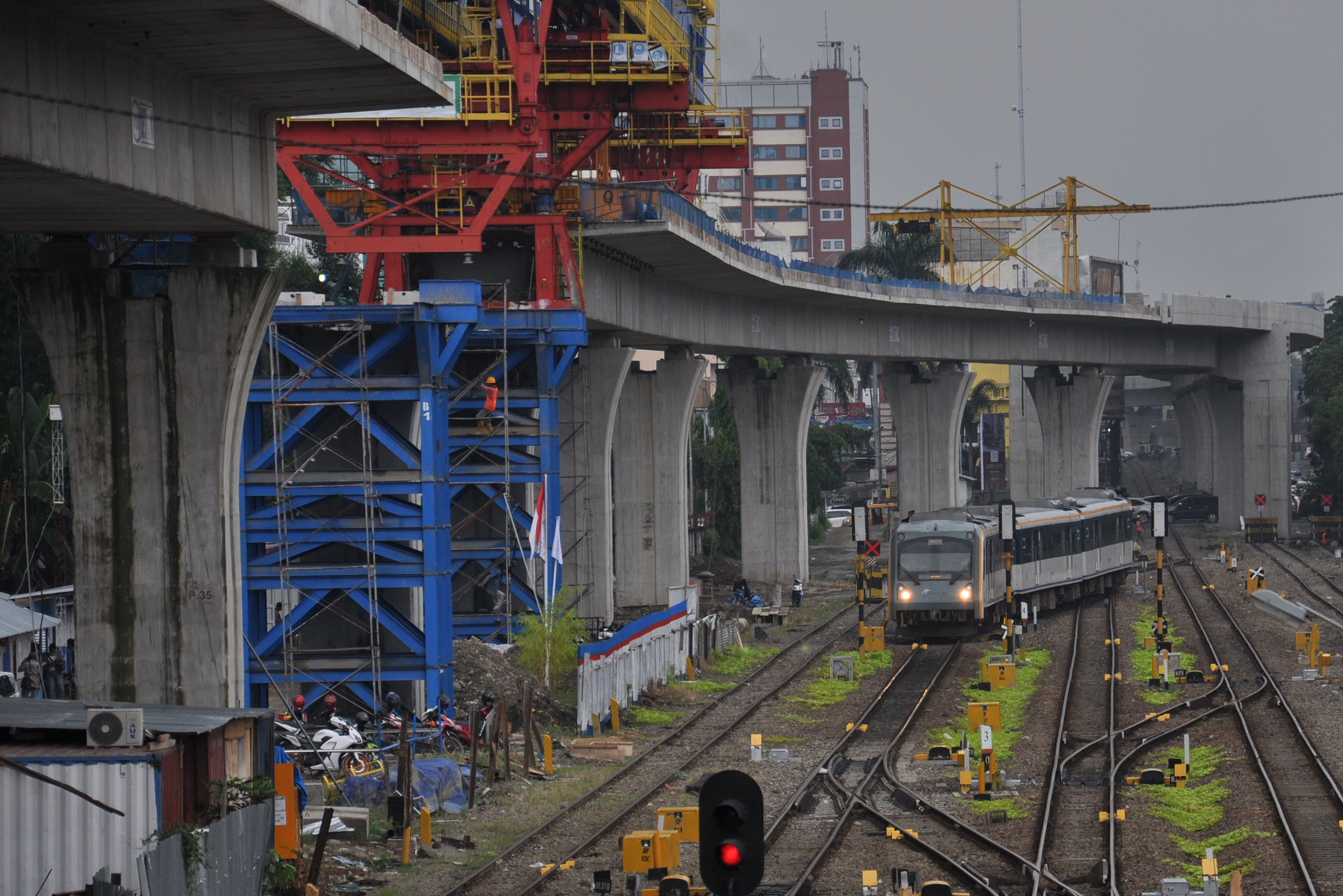 Kereta api Railink melintas di samping proyek pembangunan Stasiun Layang Kereta Api Railink Medan Besar di kota Medan.