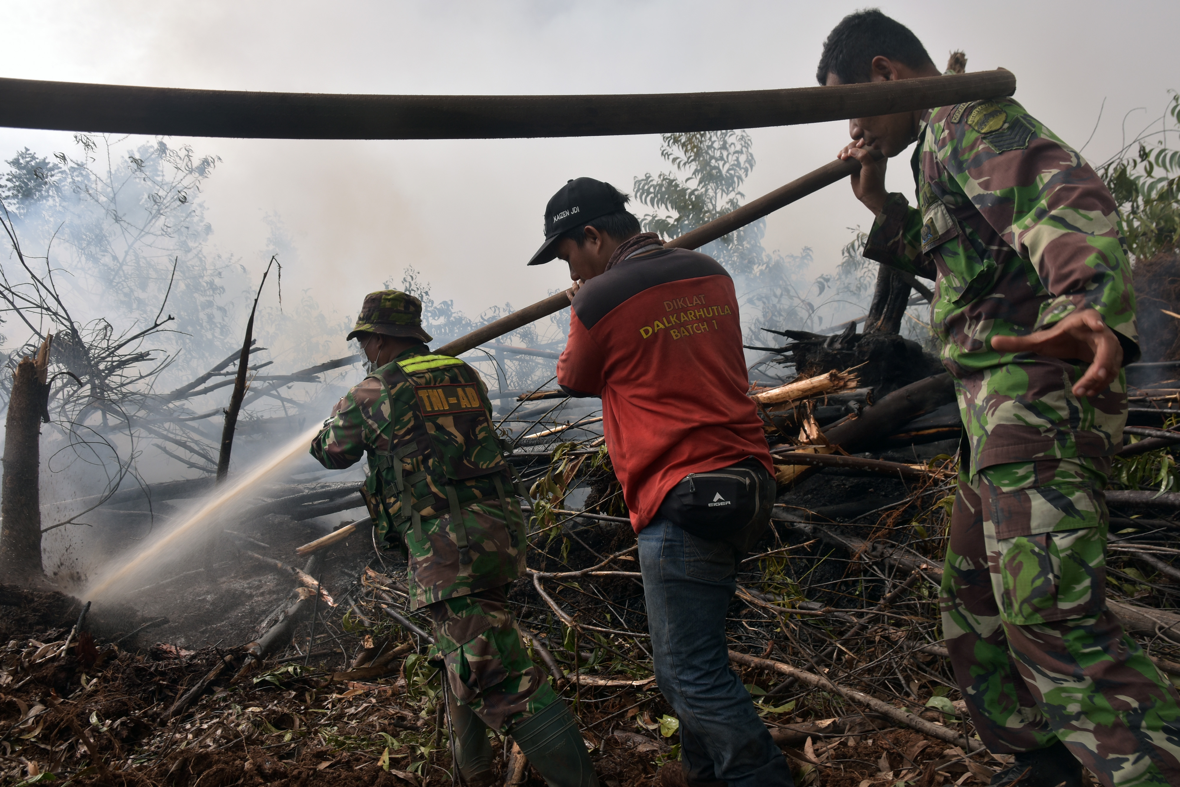 Tim gabungan  memadamkan kebakaran lahan gambut di Desa Penarikan Kecamatan Langgam Kabupaten Pelalawan, Riau, Minggu (28/7).