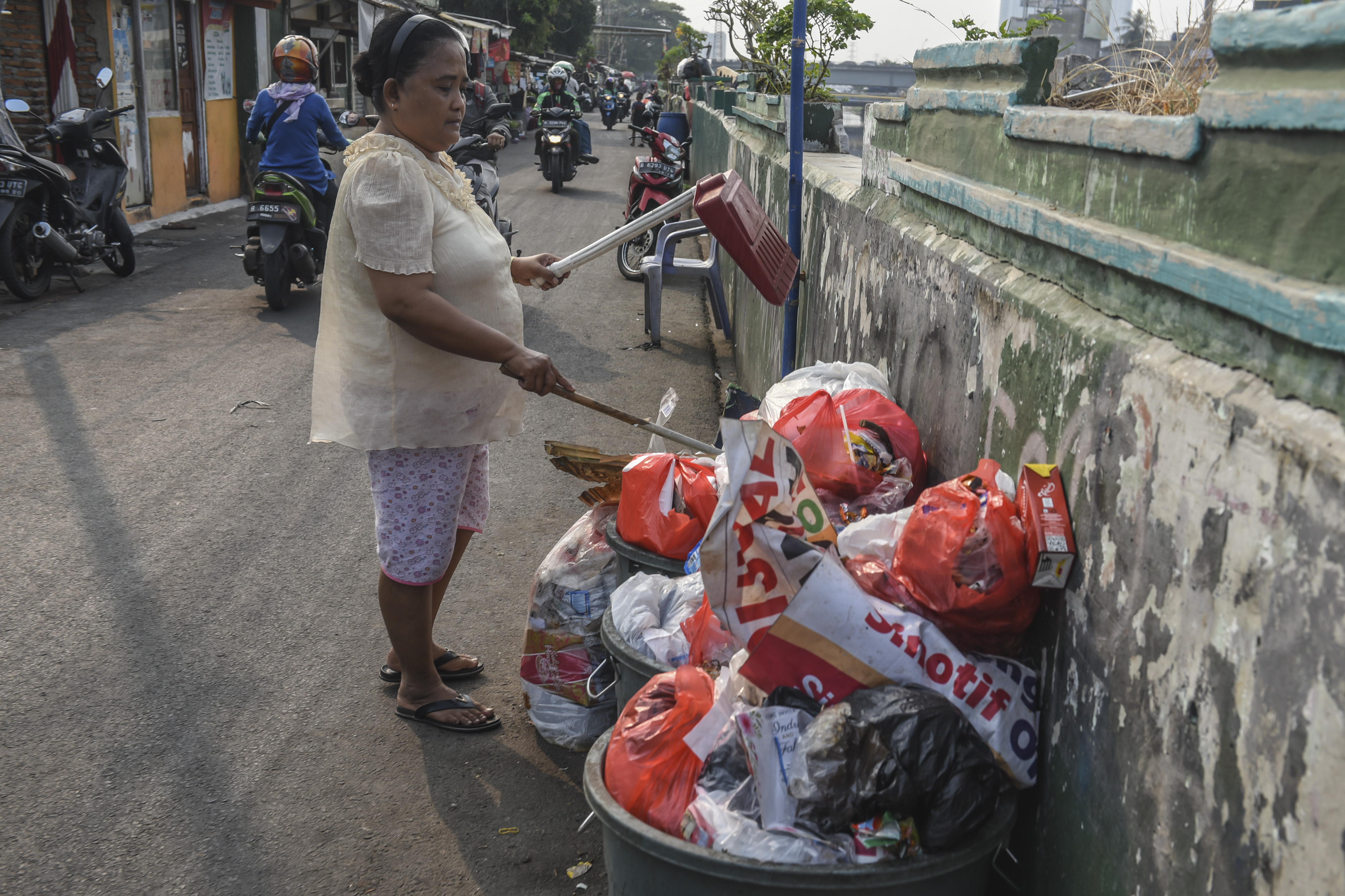 Warga membuang sampah di jalur inspeksi Banjir Kanal Barat, Jakarta.