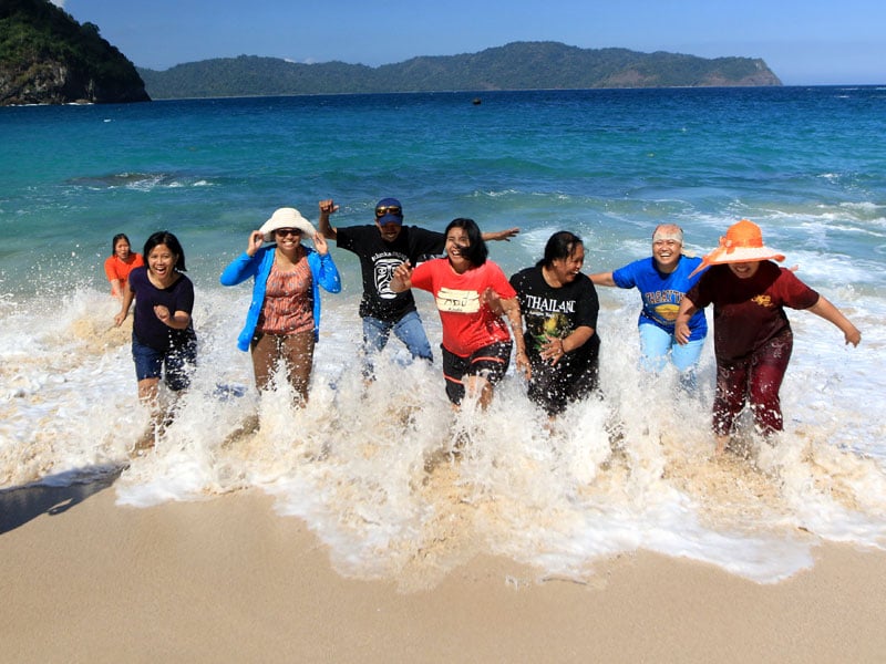 Wisatawan bermain di Pantai Teluk Hijau di Banyuwangi, Jawa Timur.