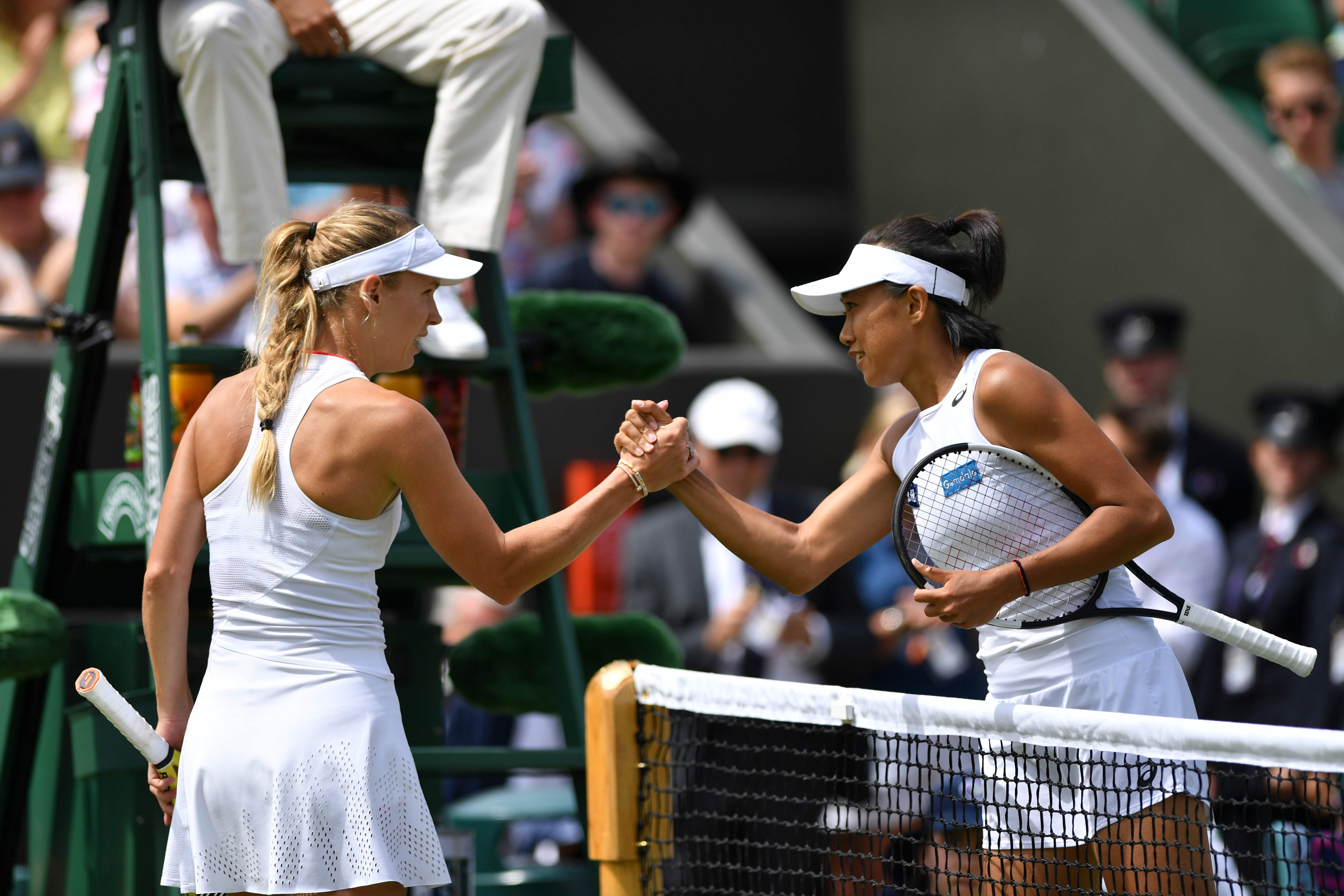  Zhang Shuai (kanan) berjabat tangan dengan petenis Denmark Caroline Wozniacki (kiri) setelah Zhang memenangi pertandingan babak ketiga