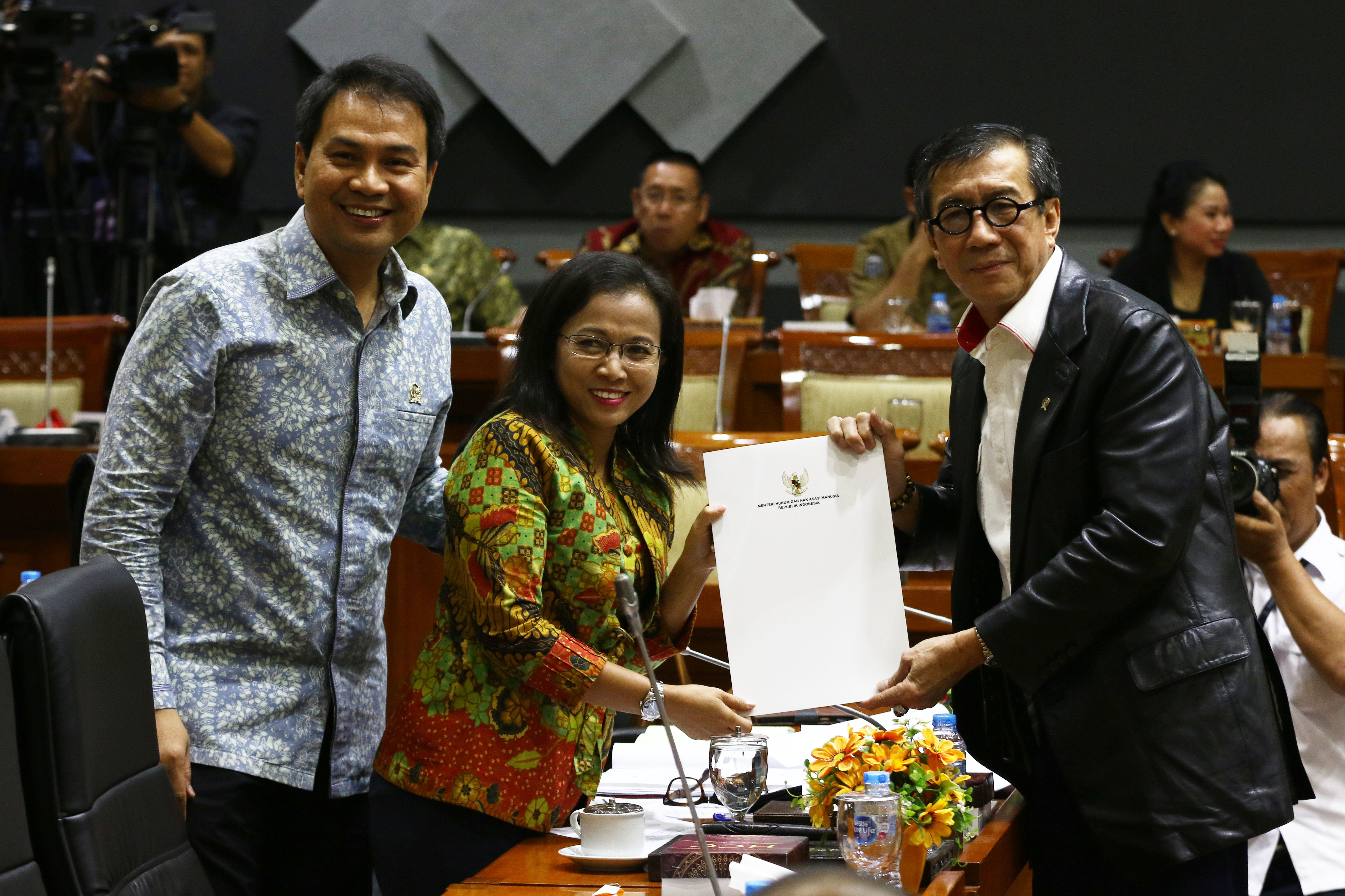 Menteri Hukum dan (HAM) Yasonna H. Laoly (kanan) menyerahkan berkas amnesti Baiq Nuril Maknun kepada Wakil Ketua Komisi III DPR Irma Suryani