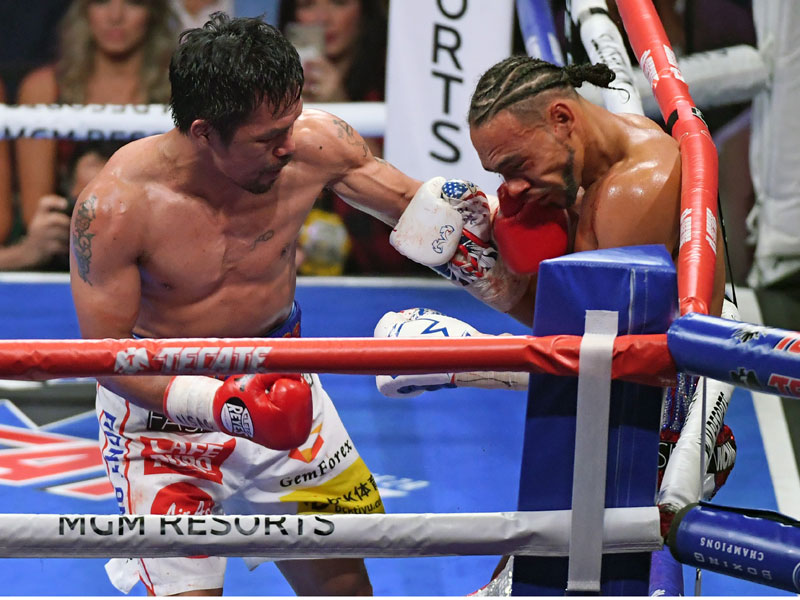 Manny Pacquiao (kiri) memukul Keith Thurman.
