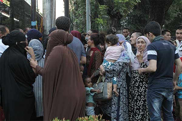 Sejumlah pencari suaka mengantre untuk memasuki bus saat akan dipindahkan dari trotoar kawasan Kebon Sirih, Jakarta, Kamis (11/7/2019).