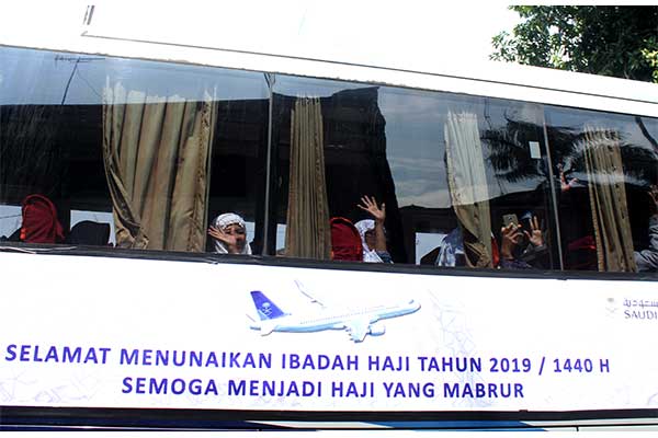 Calon jamaah haji asal Jawa Barat melambaikan tangan dari dalam bus saat keberangkatan, di Asrama Haji Embarkasi Jakarta-Bekasi
