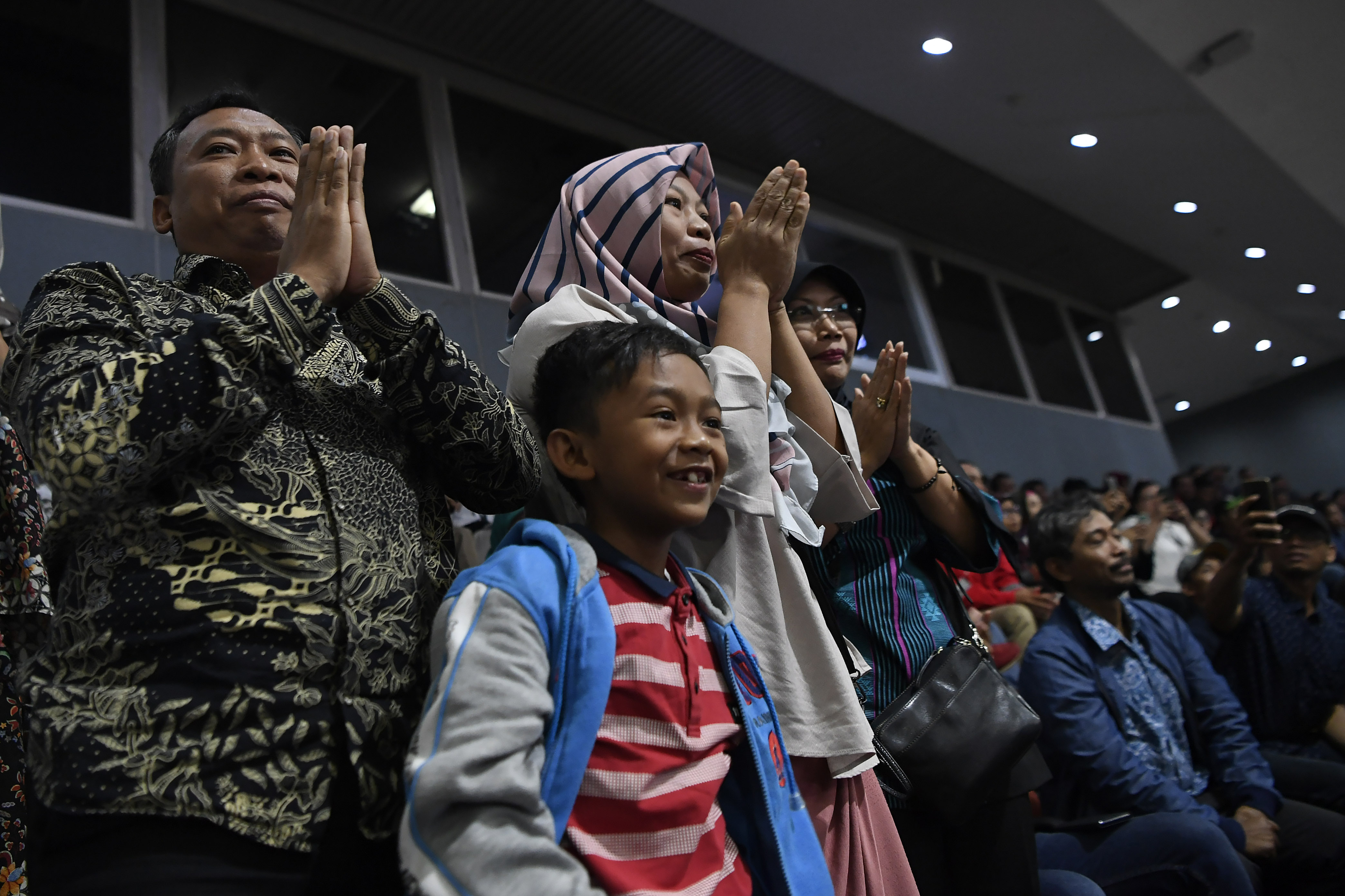 Ekspresi terpidana kasus pelanggaran UU ITE, Baiq Nuril Maknun (tengah) saat pengesahan amnesti dirinya pada rapat paripurna DPR RI, Kamis.