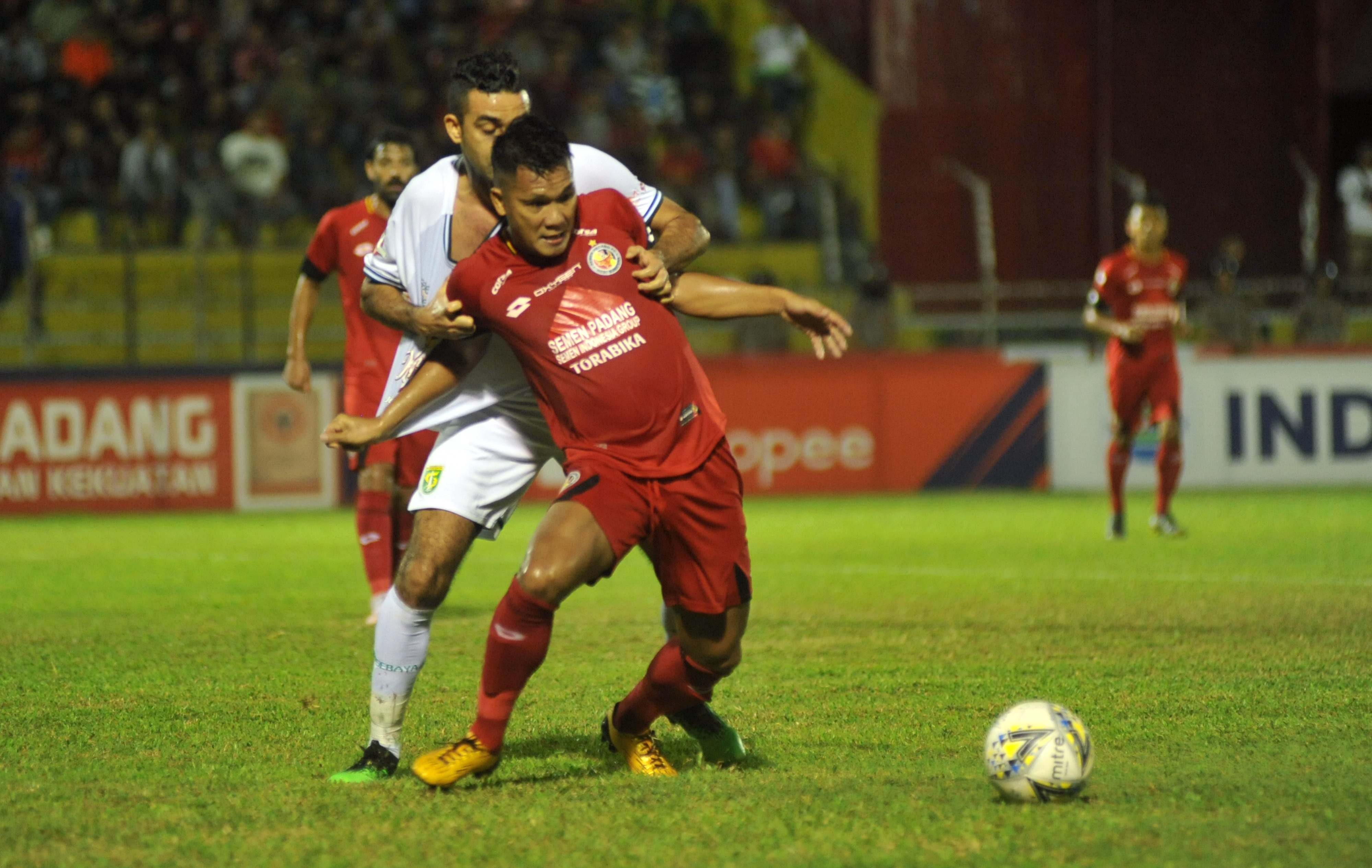 Pemain Semen Padang FC, Riski Novriansyah (kanan) berebut bola dengan pemain Persebaya, Otavio Dutra pada pertandingan lanjutan Liga 1.