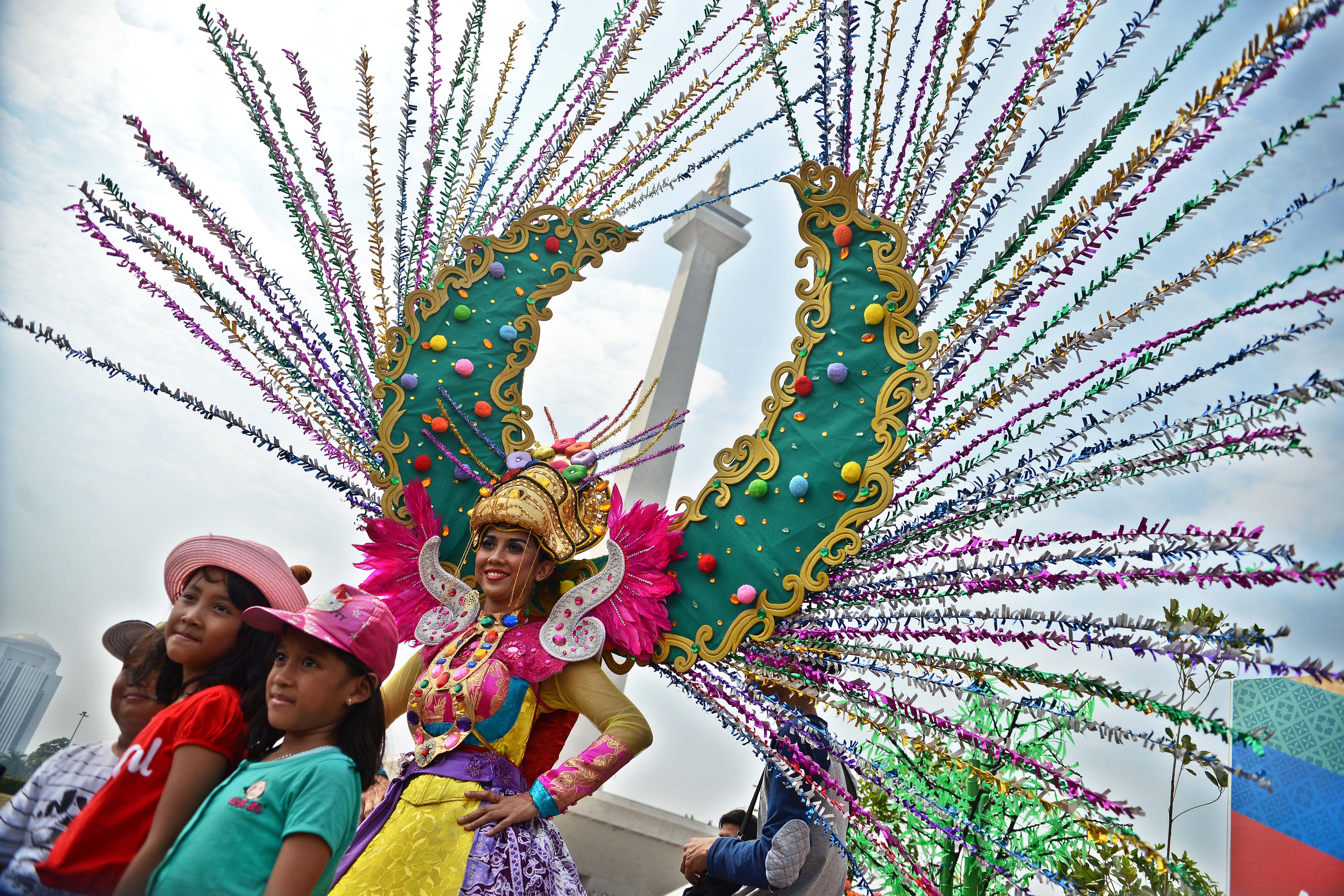 Warga masyarakat berpose dengan model yang berpakaian unik dalam gelaran Lebaran Betawi ke-12 di Monas, Jakarta, Sabtu (19/7).