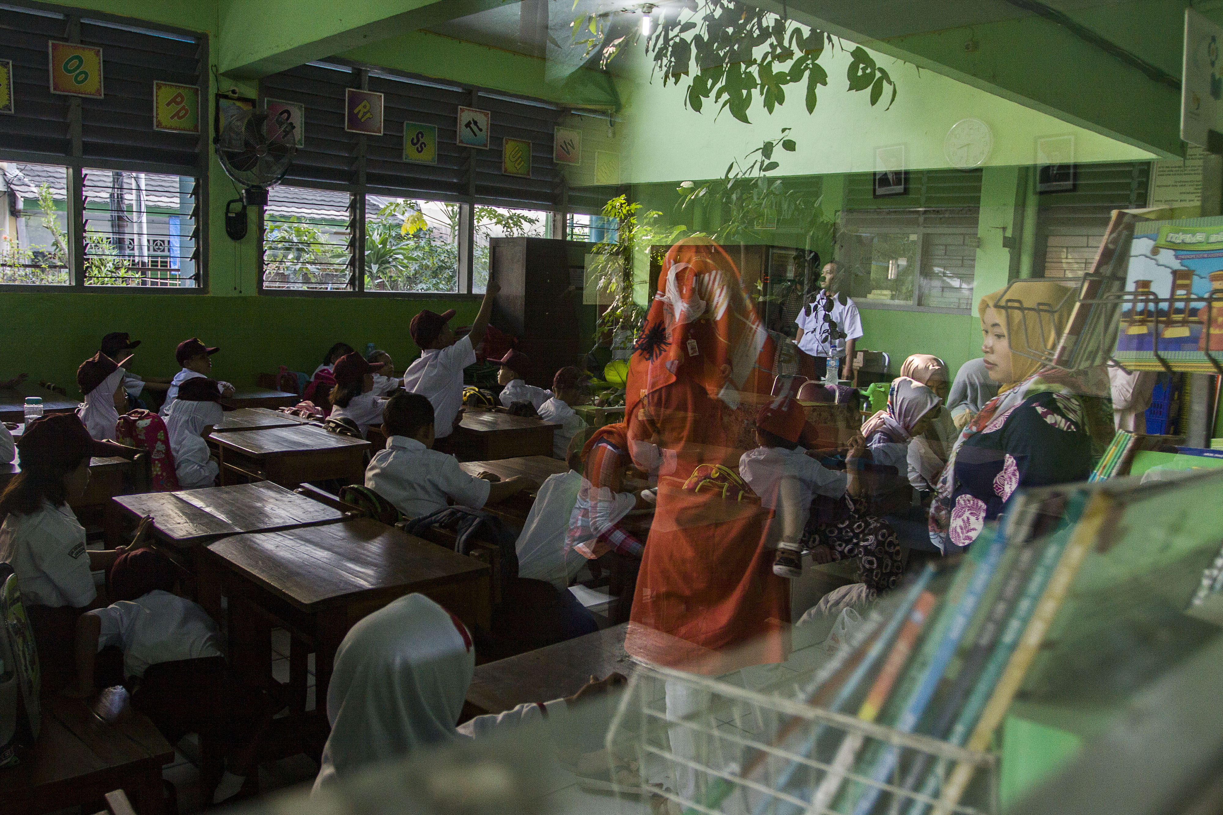  HARI PERTAMA MASUK SEKOLAH: Sejumlah orang tua murid mengawasi anaknya pada hari pertama masuk sekolah di SDN Kampung Melayu 01/02,  