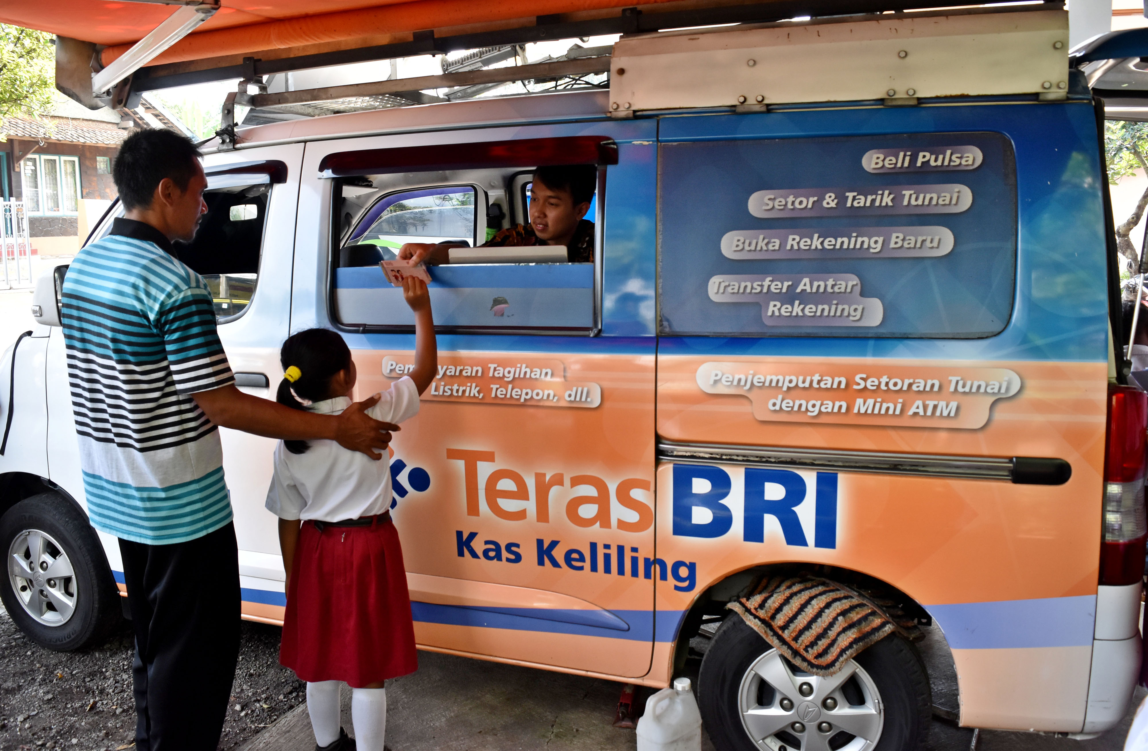 Warga bersama anaknya menerima dana Program Indonesia Pintar (PIP) dari petugas layanan keliling BRI di Bawen, Jateng