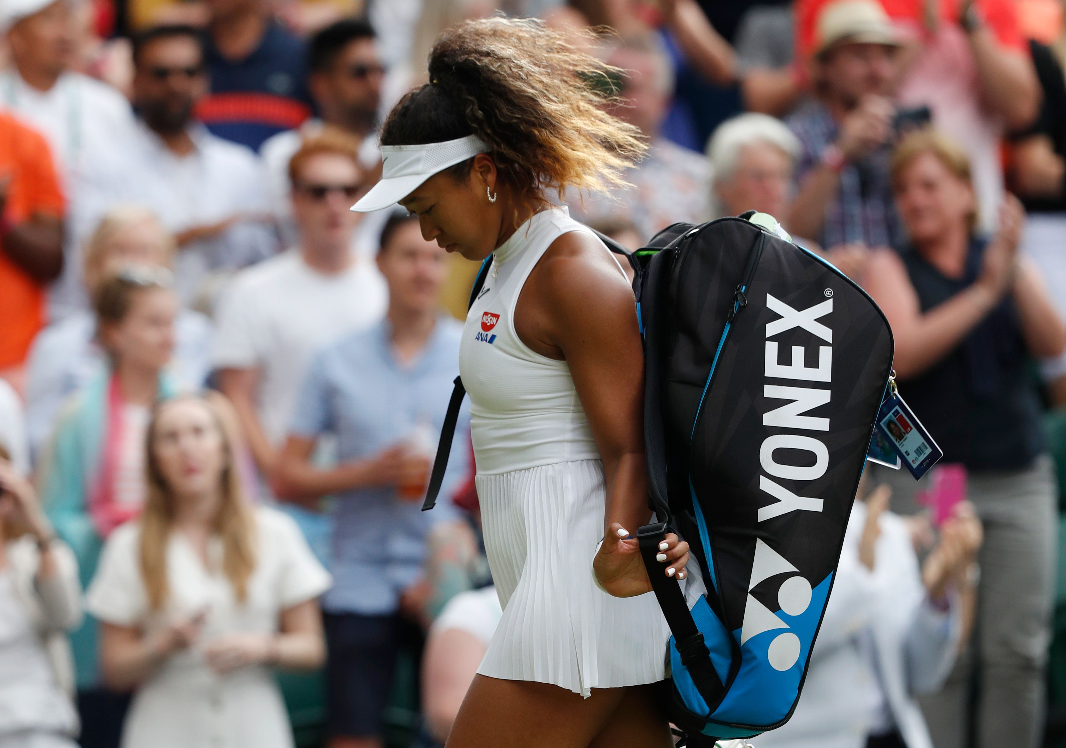 Naomi Osaka tertunduk meninggalkan lapangan usai tersingkir di putaran pertama Wimbledon.