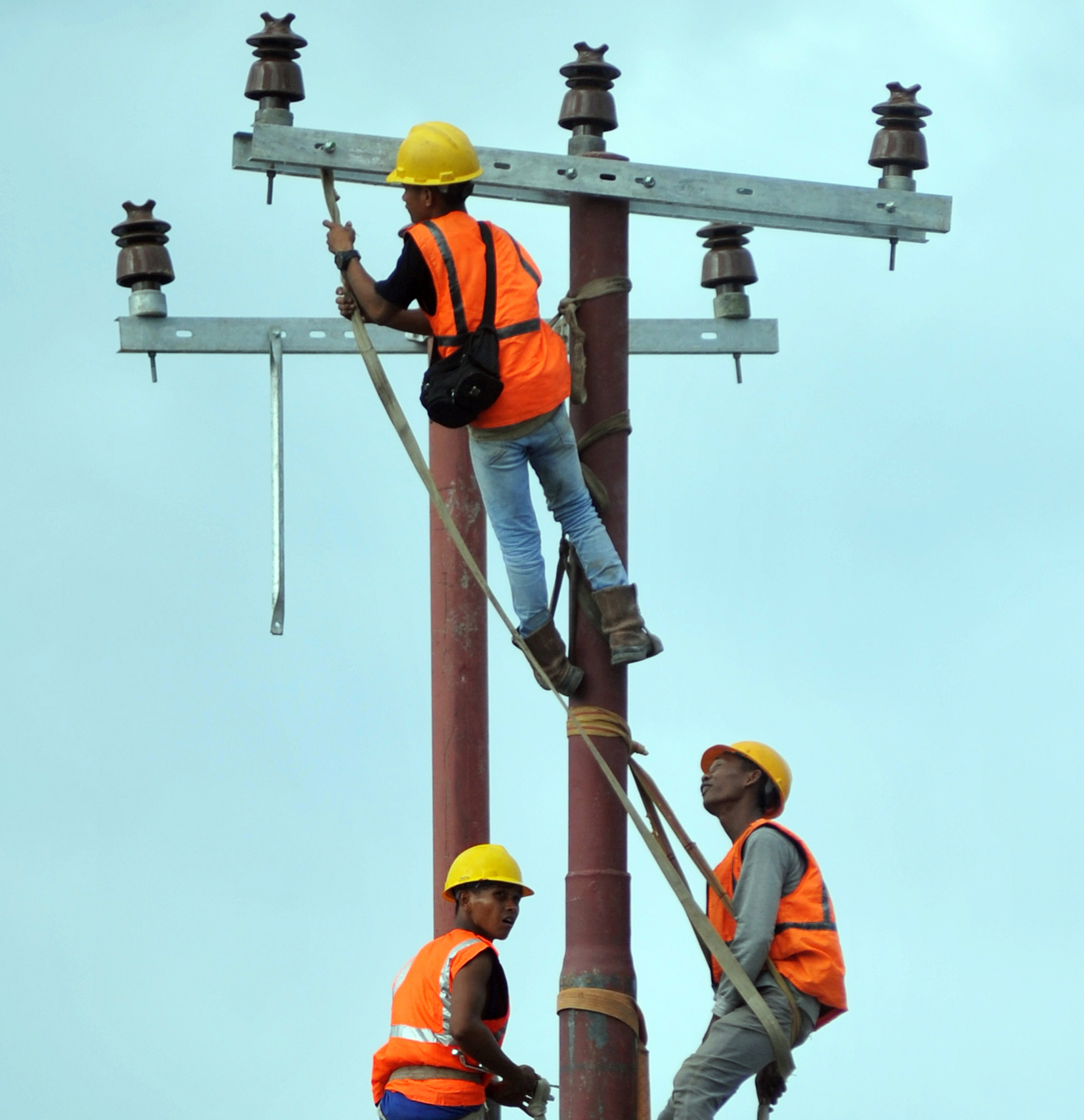 Petugas memasang jaringan listrik baru