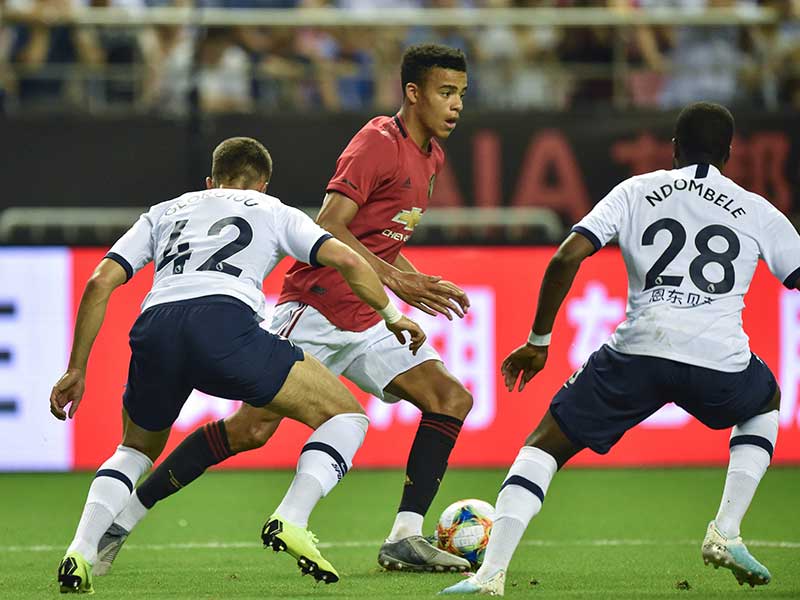 Dua pemain Tottenham Hotspur (kostum putih) berusaha menghentikan laju bintang muda Manchester United, Mason Greenwood (tengah)