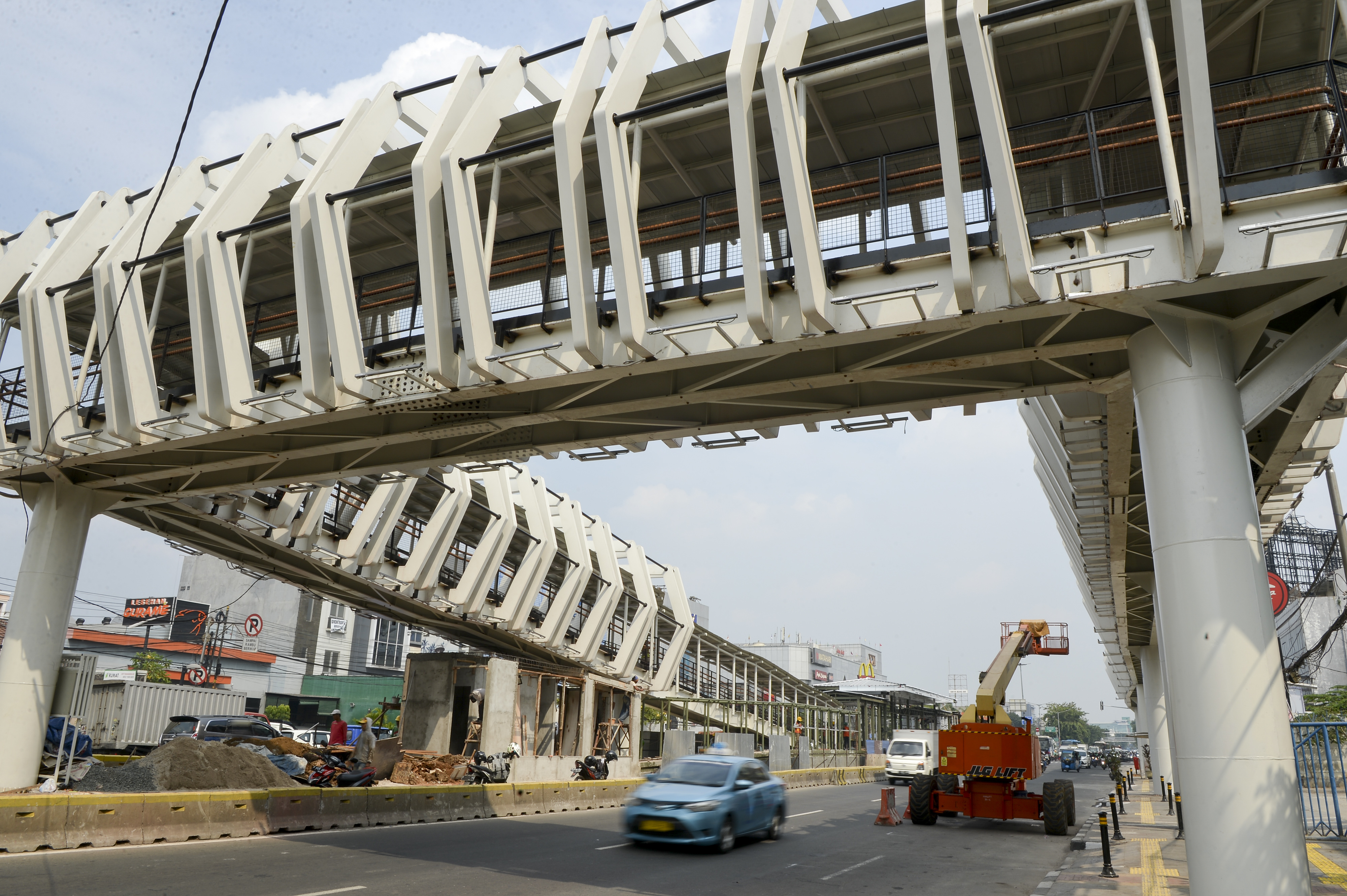 Pekerja menyelesaikan pembangunan Jembatan Penyeberangan Orang (JPO) atau Skybridge di Jalan Pemuda, Rawamangun, Jakarta.