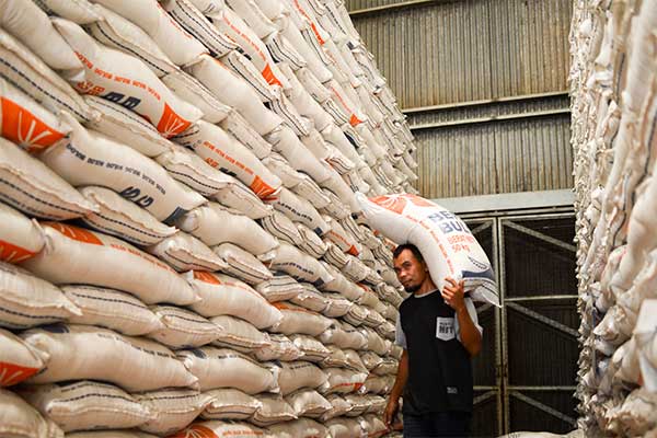 Pekerja memanggul karung beras Bulog di Gudang Bulog Kelapa Gading, Jakarta, Kamis (4/7/2019).