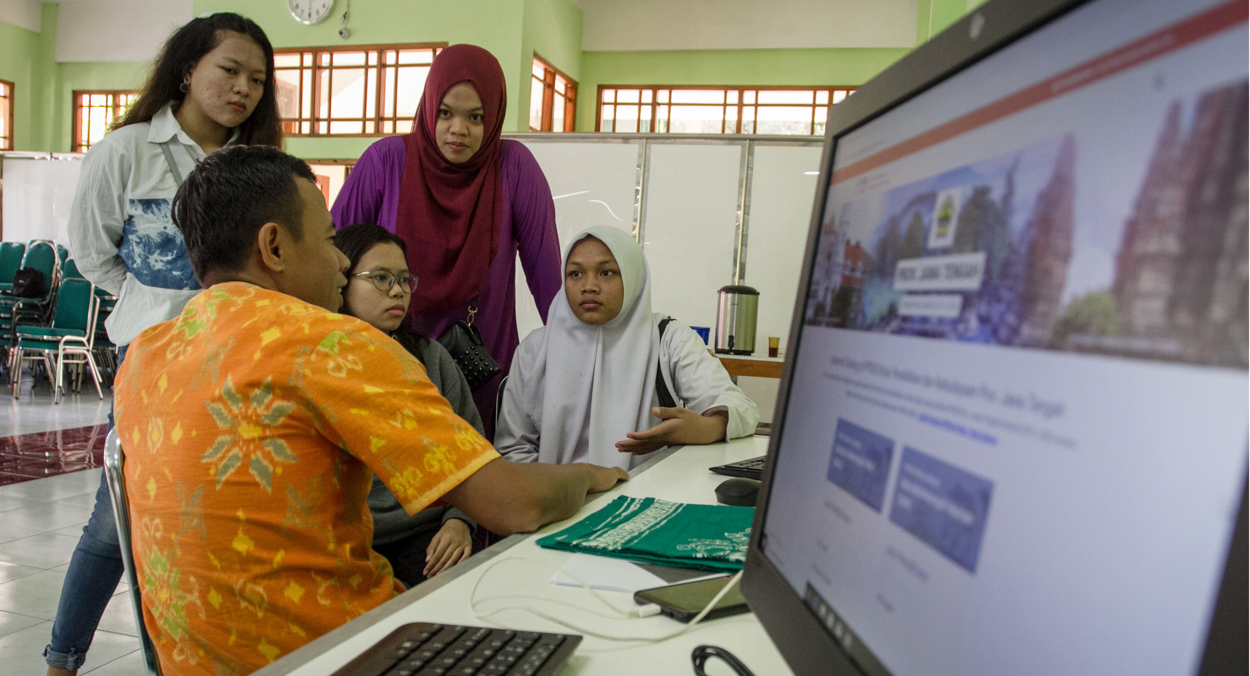 Siswa dan wali murid berkonsultasi dengan petugas pusat layanan informasi Penerimaan Peserta Didik Baru (PPDB) 