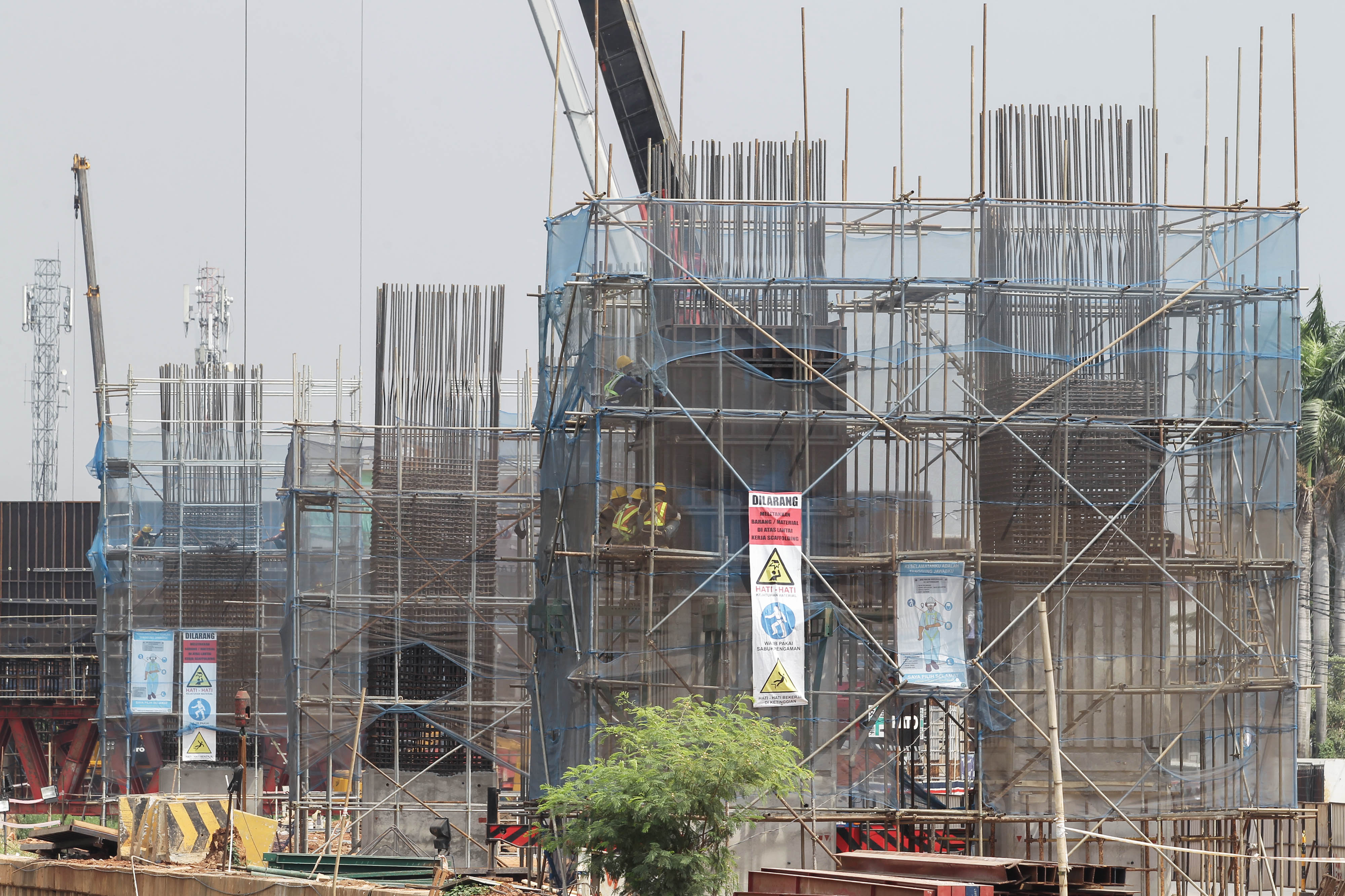  Pekerja menyelesaikan proyek pembangunan Tol Becakayu sesi 2A yang berada di sepanjang Jalan KH. Noer Ali, Bekasi, Jawa Barat