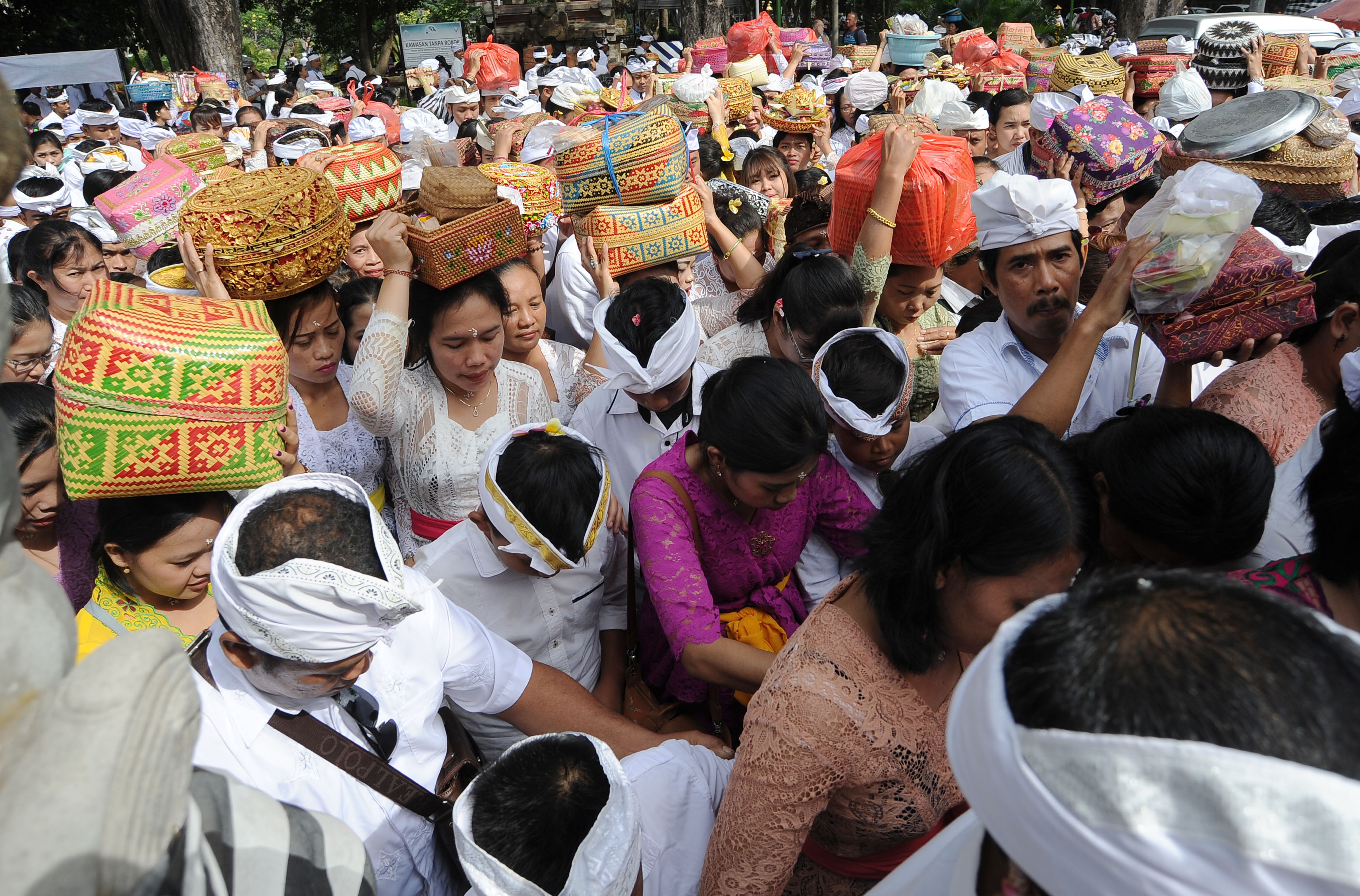 Umat Hindu membawa sesajen memasuki pura sebelum persembahyangan bersama Hari Raya Galungan di Pura Jagatnatha, Denpasar, Bali.
