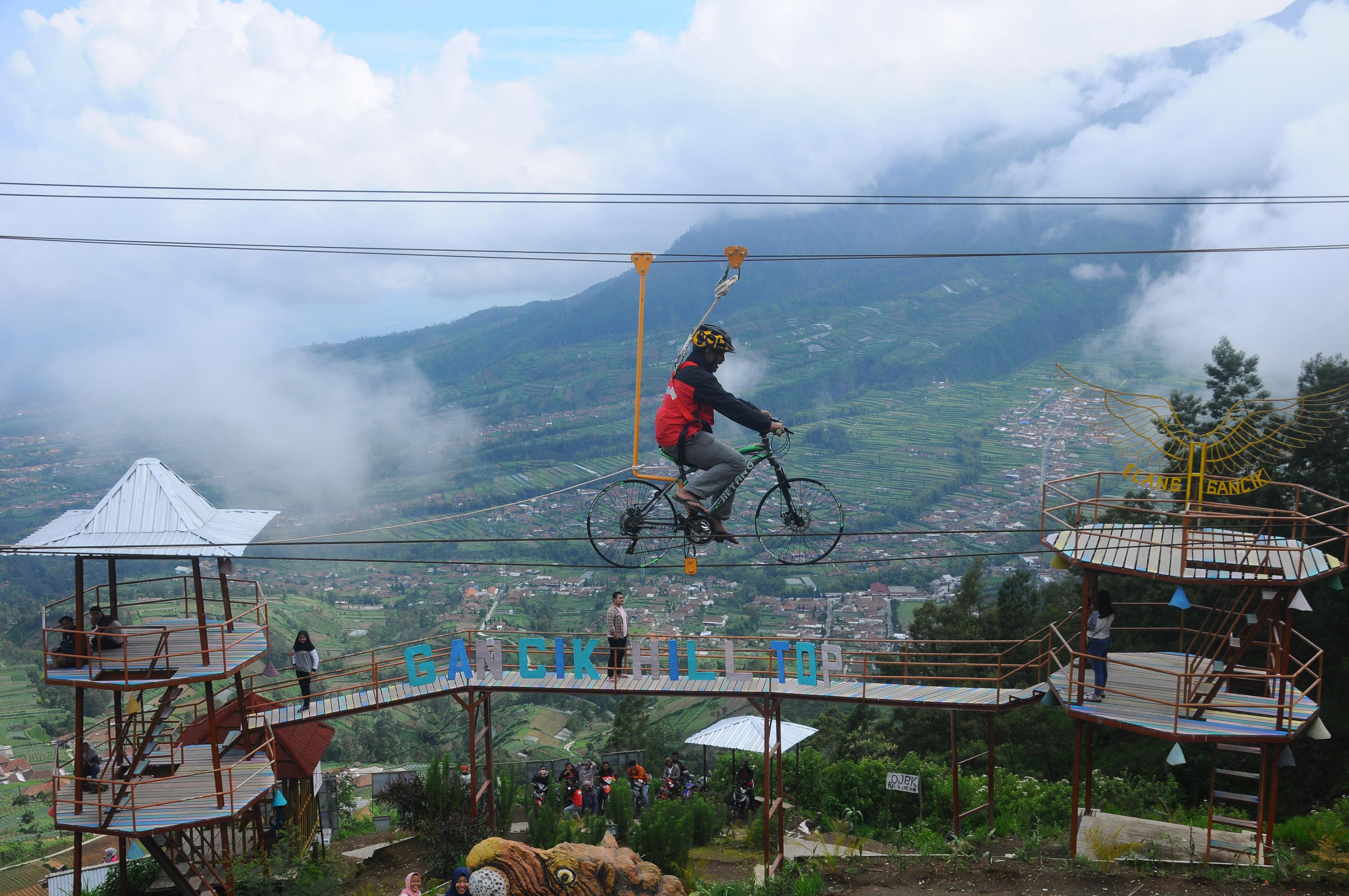Wisatawan menggunakan wahana sepeda gantung di kawasan wisata lereng Gunung Merbabu di Gacik, Selo, Boyolali, Jawa Tengah.