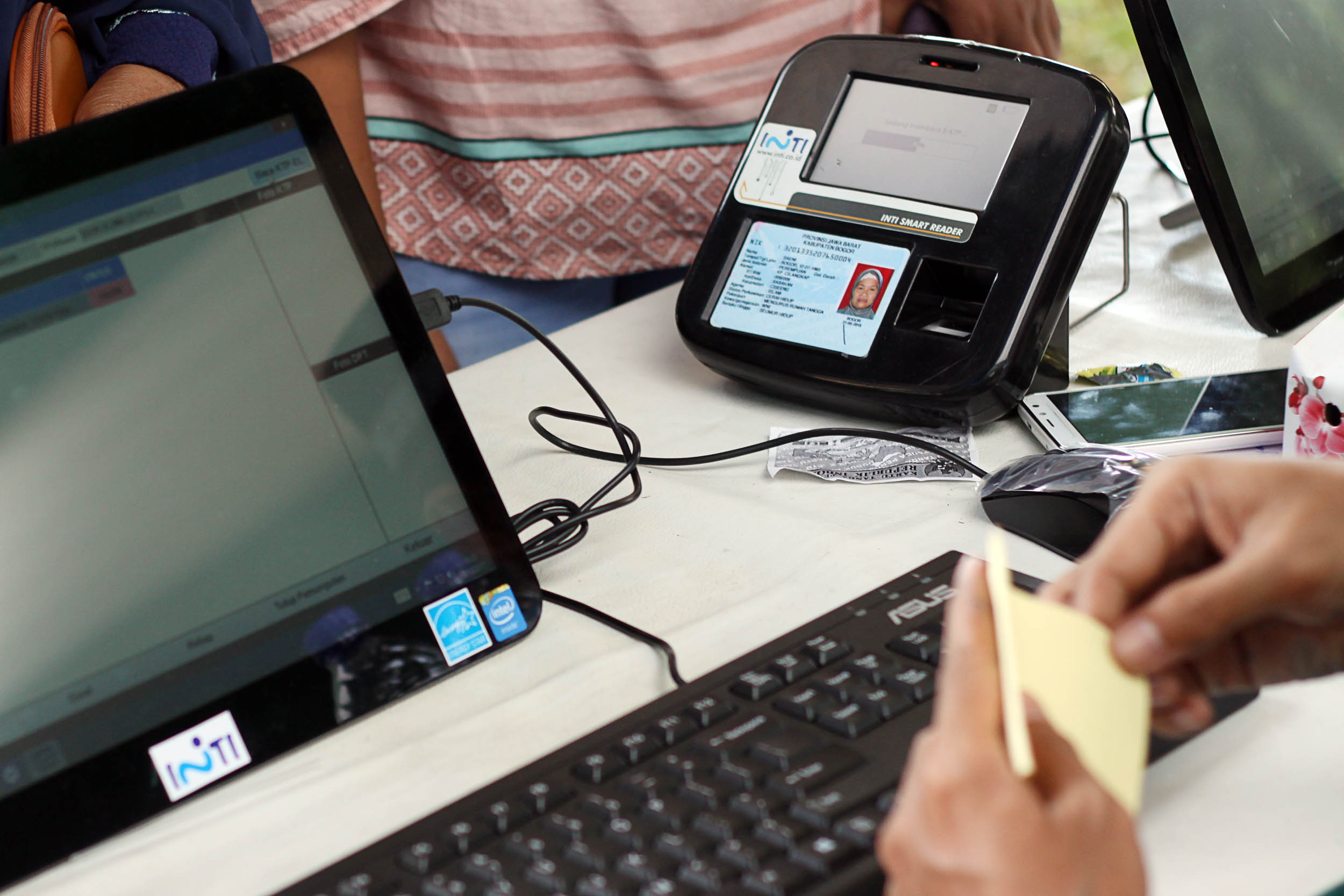 Pemilih mengantri untuk verifiikasi (E-Verifikasi) KTP saat akan memberikan hak suaranya melalui sistem komputerisasi elektronik (E-Voting) 