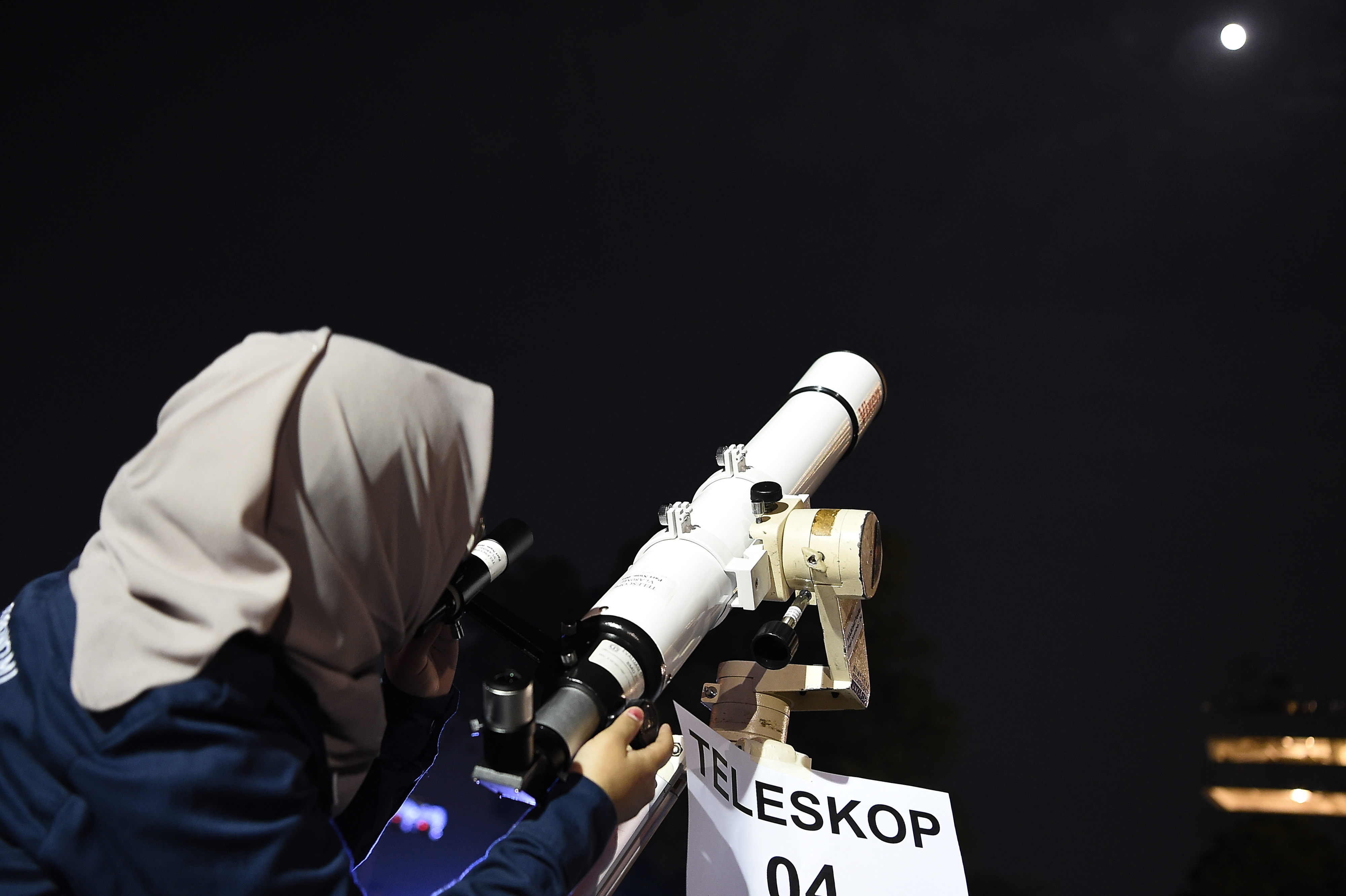 Anggota Himpunan Astronomi Amatir Jakarta mencoba mengamati bulan dari teleskop milik Planetarium, Selasa (16/7).