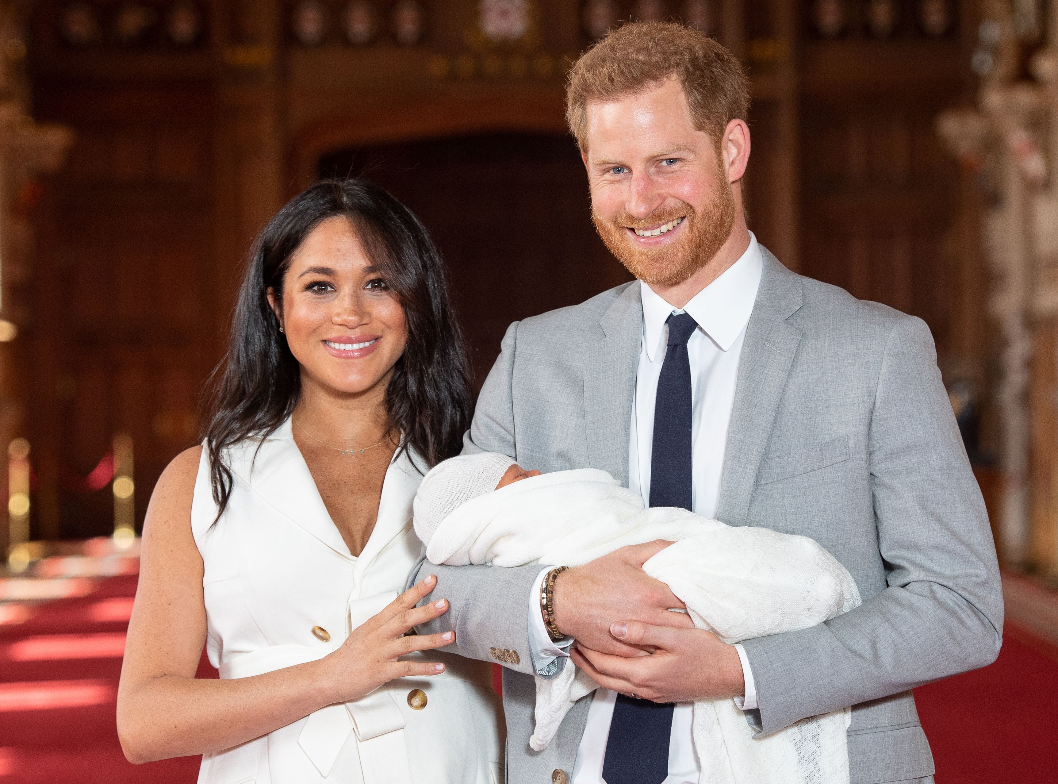 Pangeran Harry (kanan) bersama istrinya Meghan menggendong anak mereka Archie.