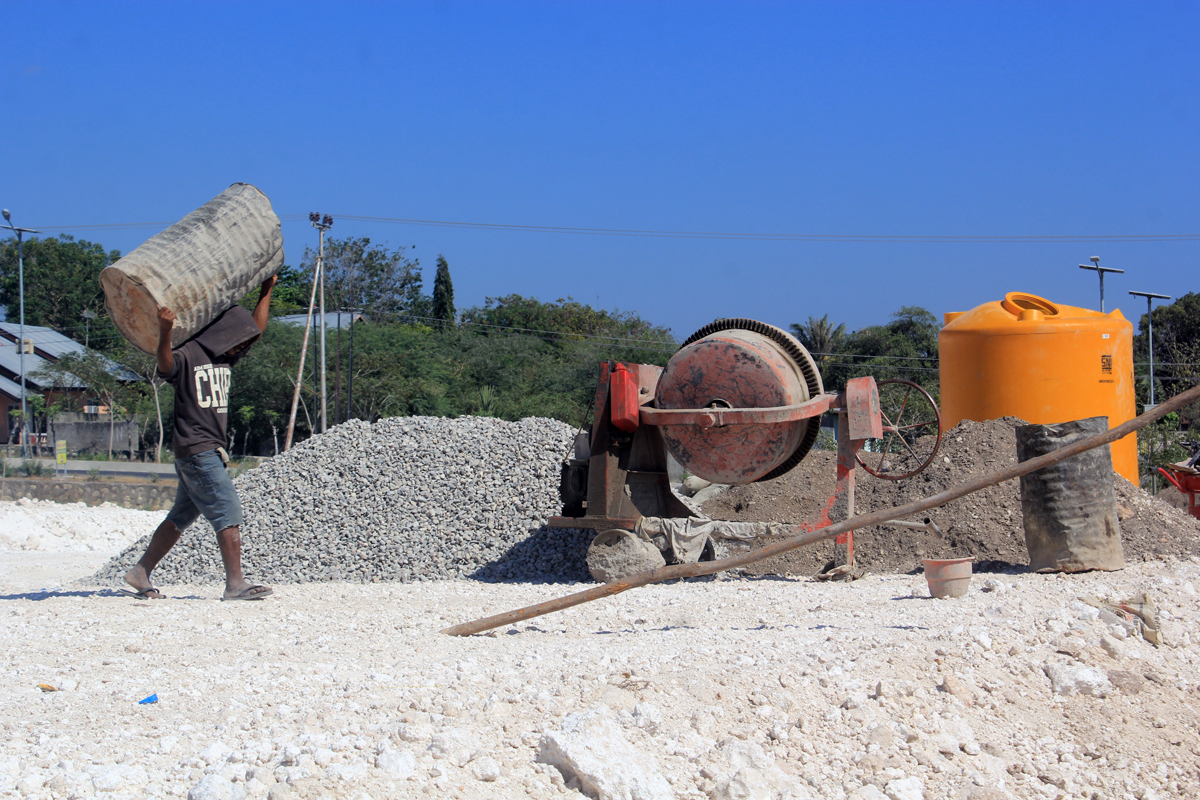 Pekerja melintas di area pembangunan Terminal Tipe A di Kota Kupang, Nusa Tenggara Timur (NTT), Senin (8/7). 