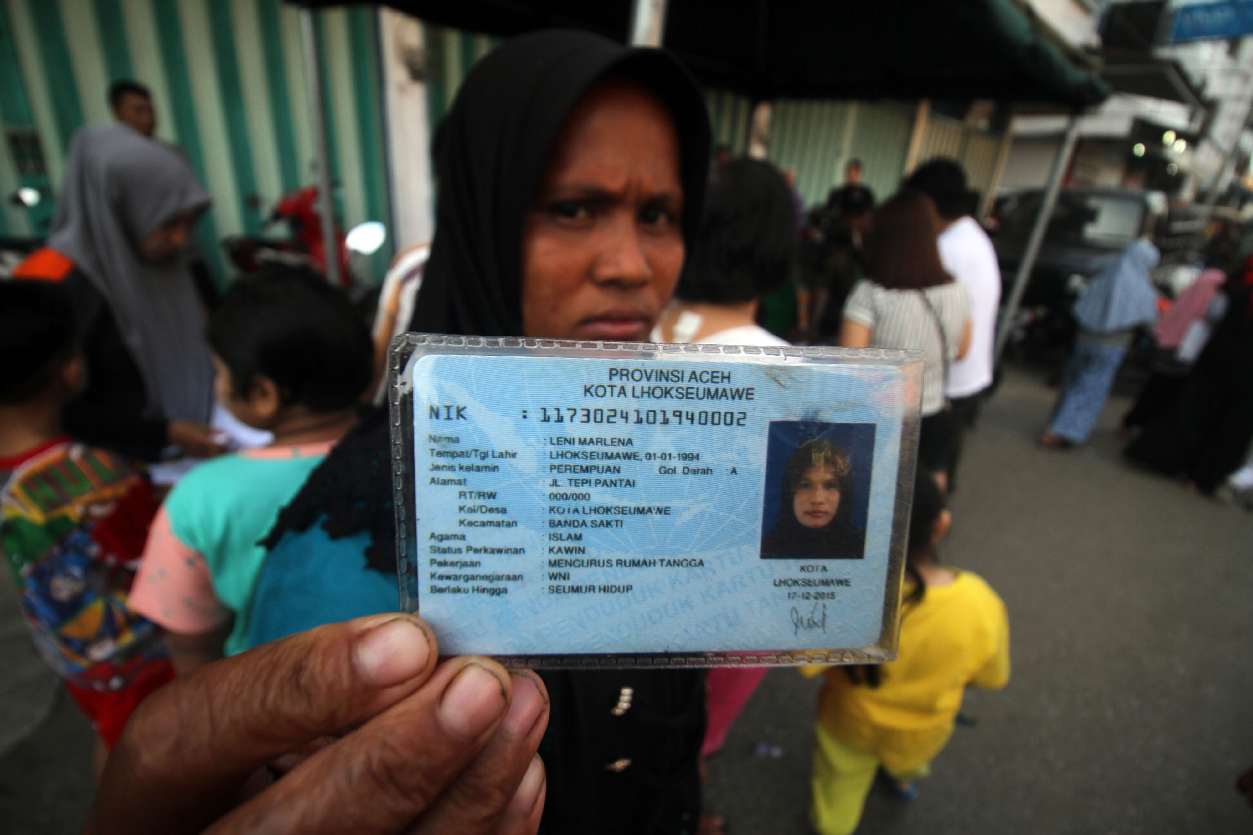 Warga Kelurahan Kota, Kota Lhokseumawe menunjukkan KTP-E miliknya.