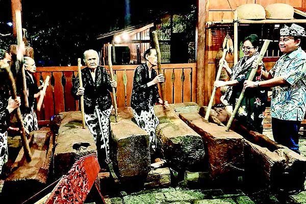 Deputi Gubernur Senior BI, Mirza Adityaswara (kanan), bersama warga memukul lesung di Desa Adat Kemiren, Banyuwangi.