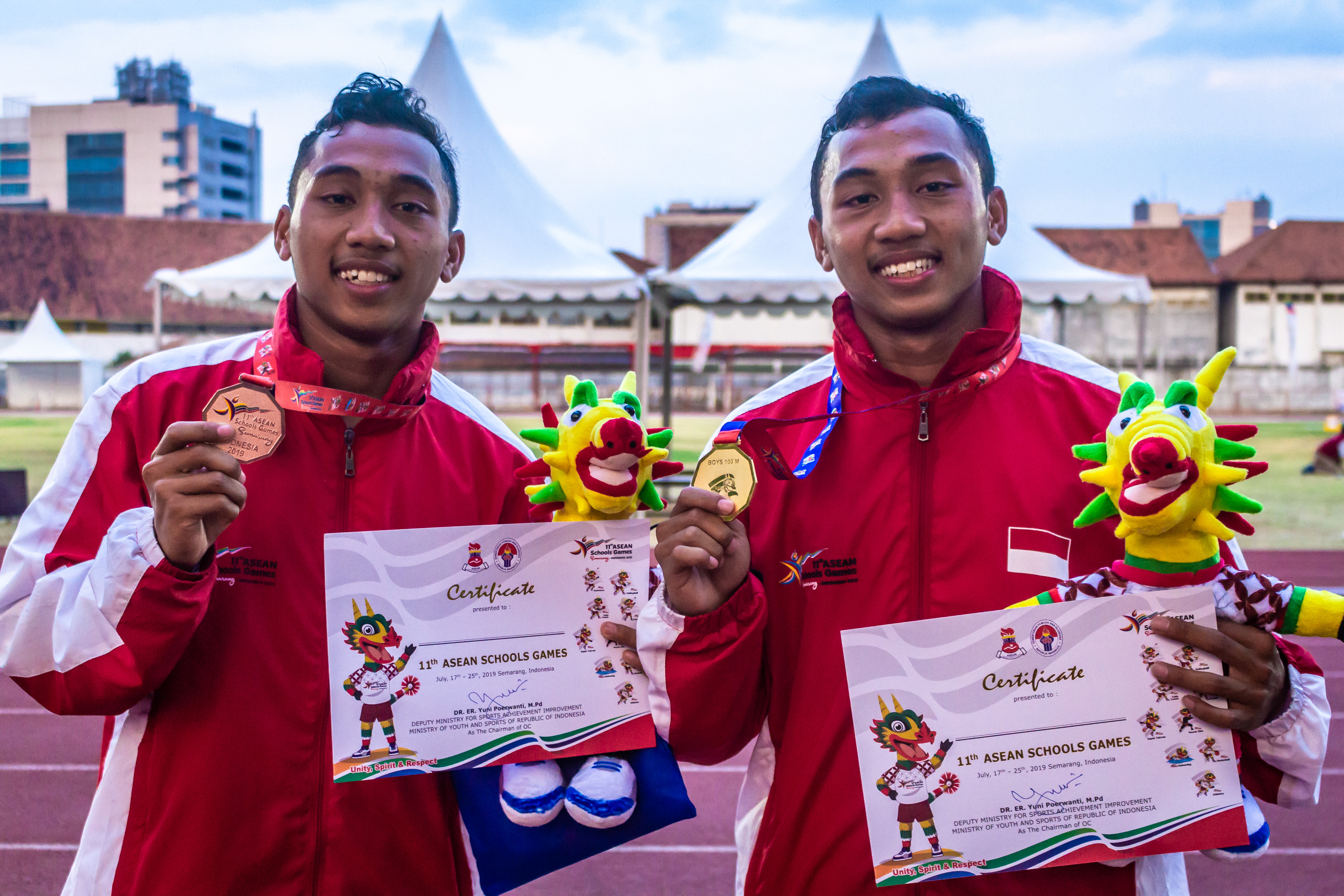  Pelari Indonesia Adith Rico Pradana (kanan) dan Adith Richi Pradana (kiri) berpose usai penyerahan medali pada final Lari 100 meter