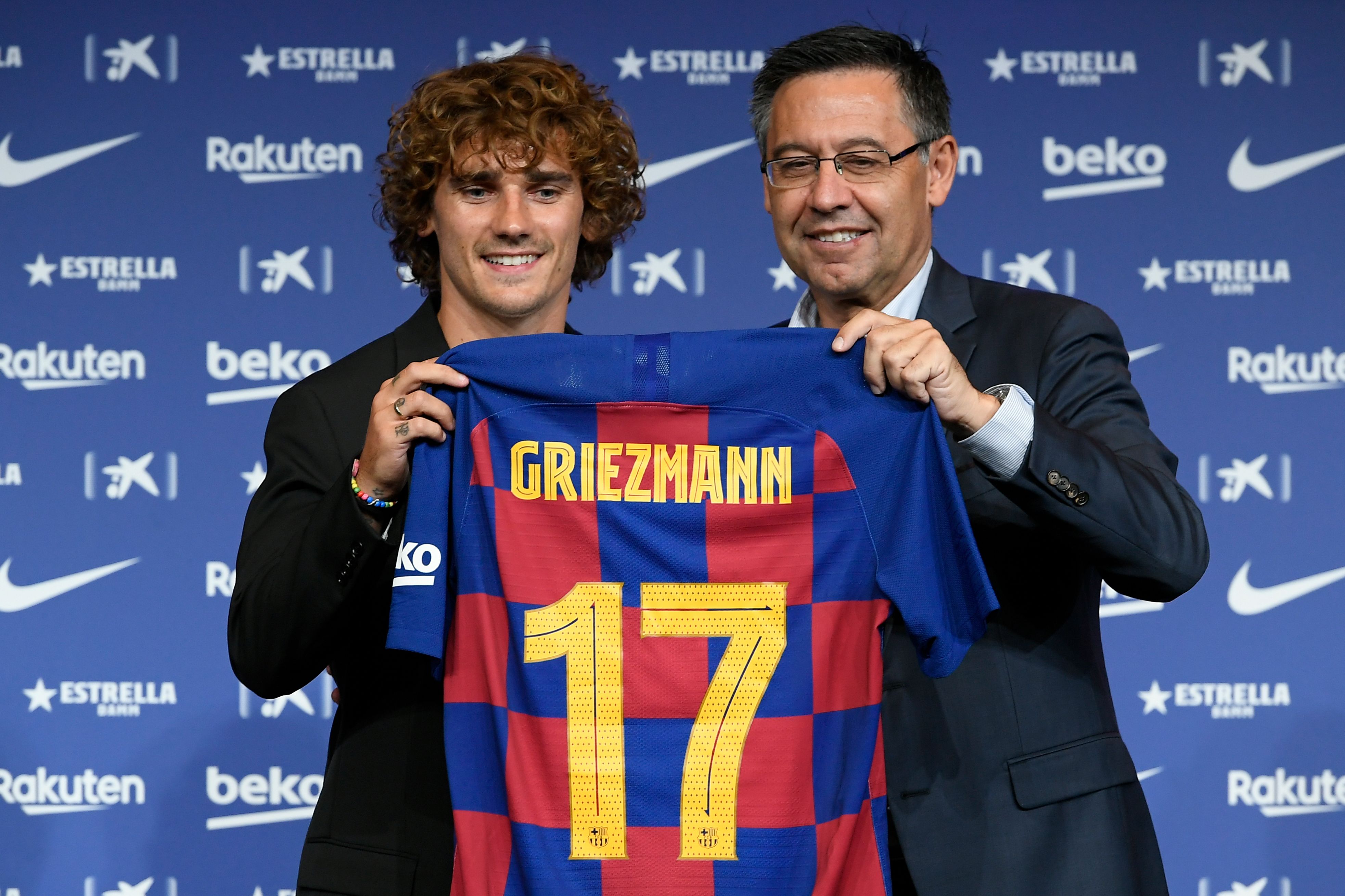 Antoine Griezmann (kiri) berpose dengan Presiden Barcelona Josep Maria Bartomeu saat diperkenalkan di Camp Nou.
