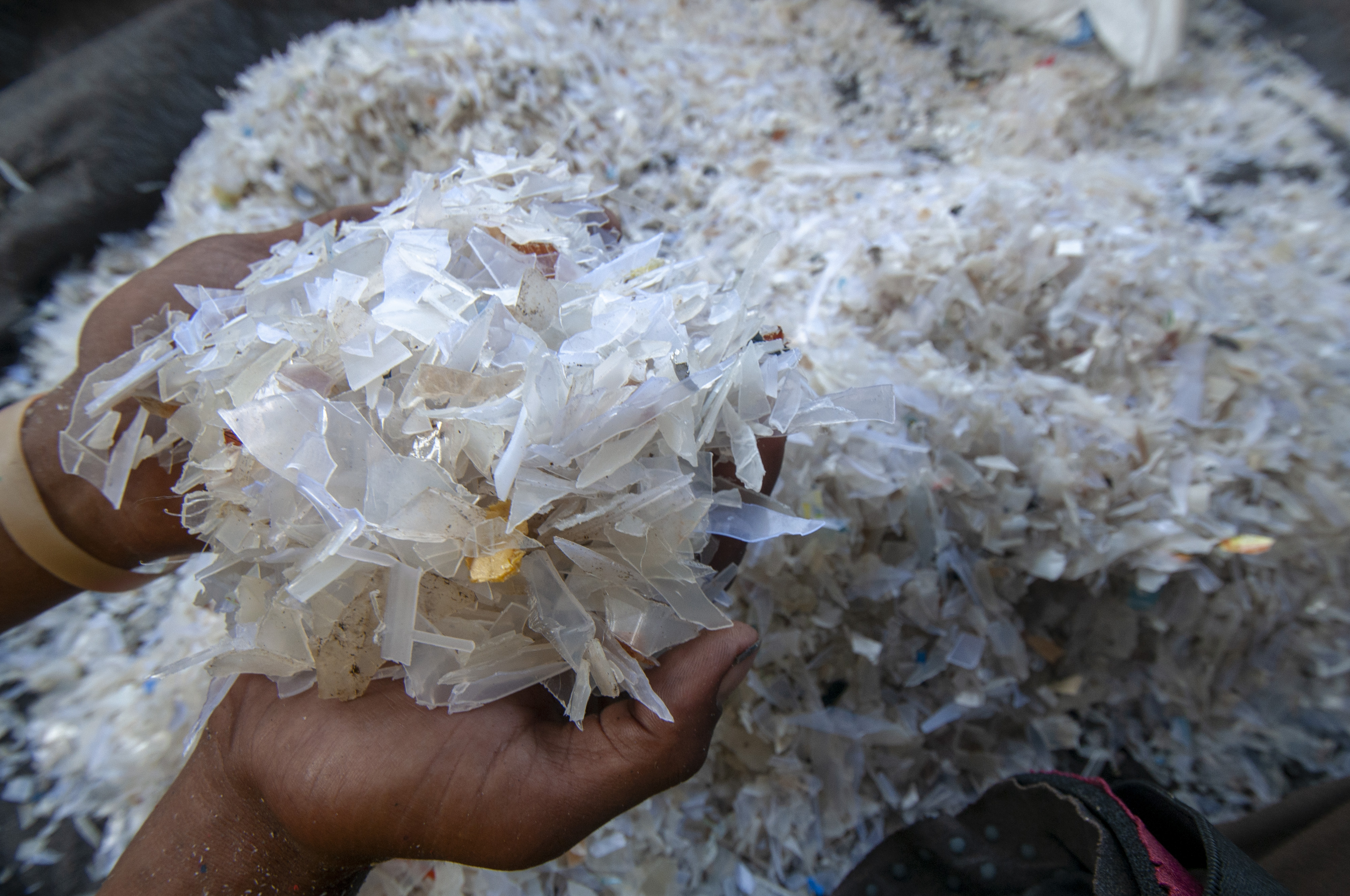 Pekerja menunjukkan blow atau potongan-potongan kecil plastik setelah diolah di tempat pengolahan sampah