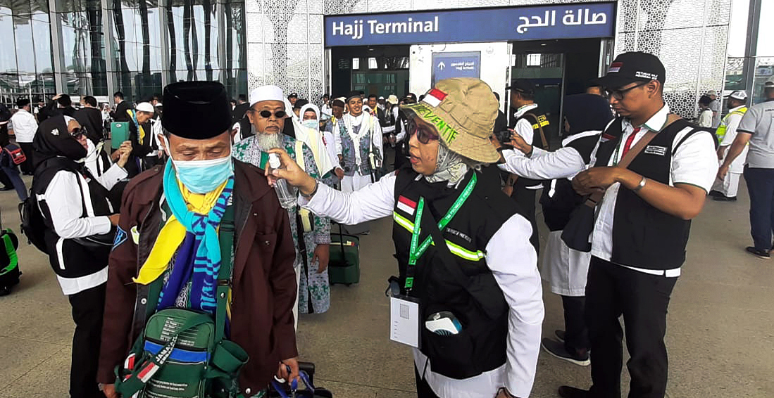Petugas menyemprotkan air ke jemaah haji kloter pertama yang baru mendarat di Bandara Internasional Amir Muhammad bin Abdul Aziz, Madinah