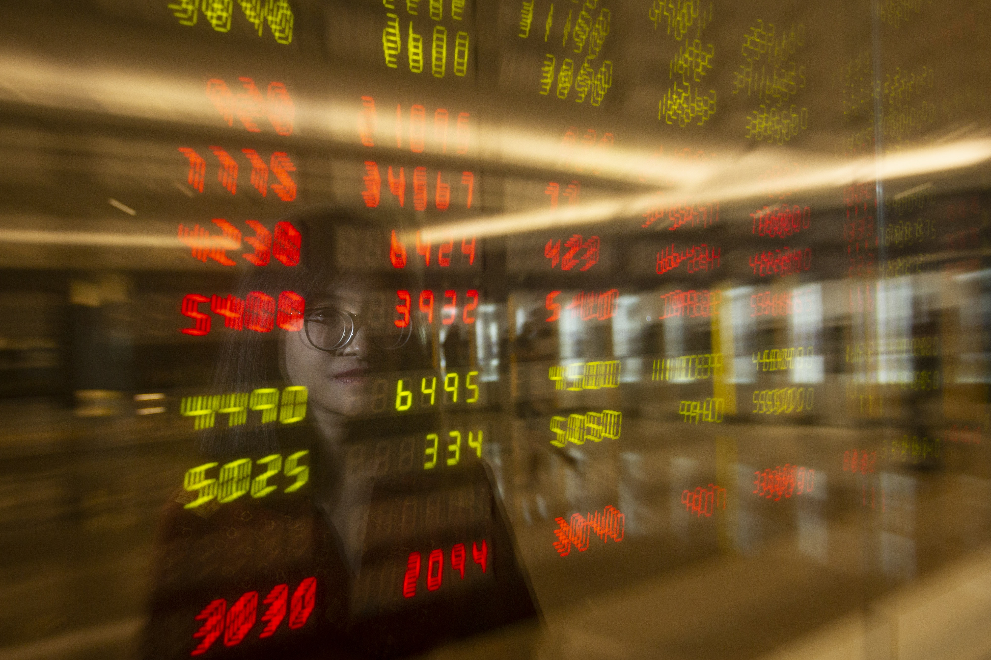 Pegawai mengamati layar pergerakan saham di Mandiri Sekuritas, Jakarta.