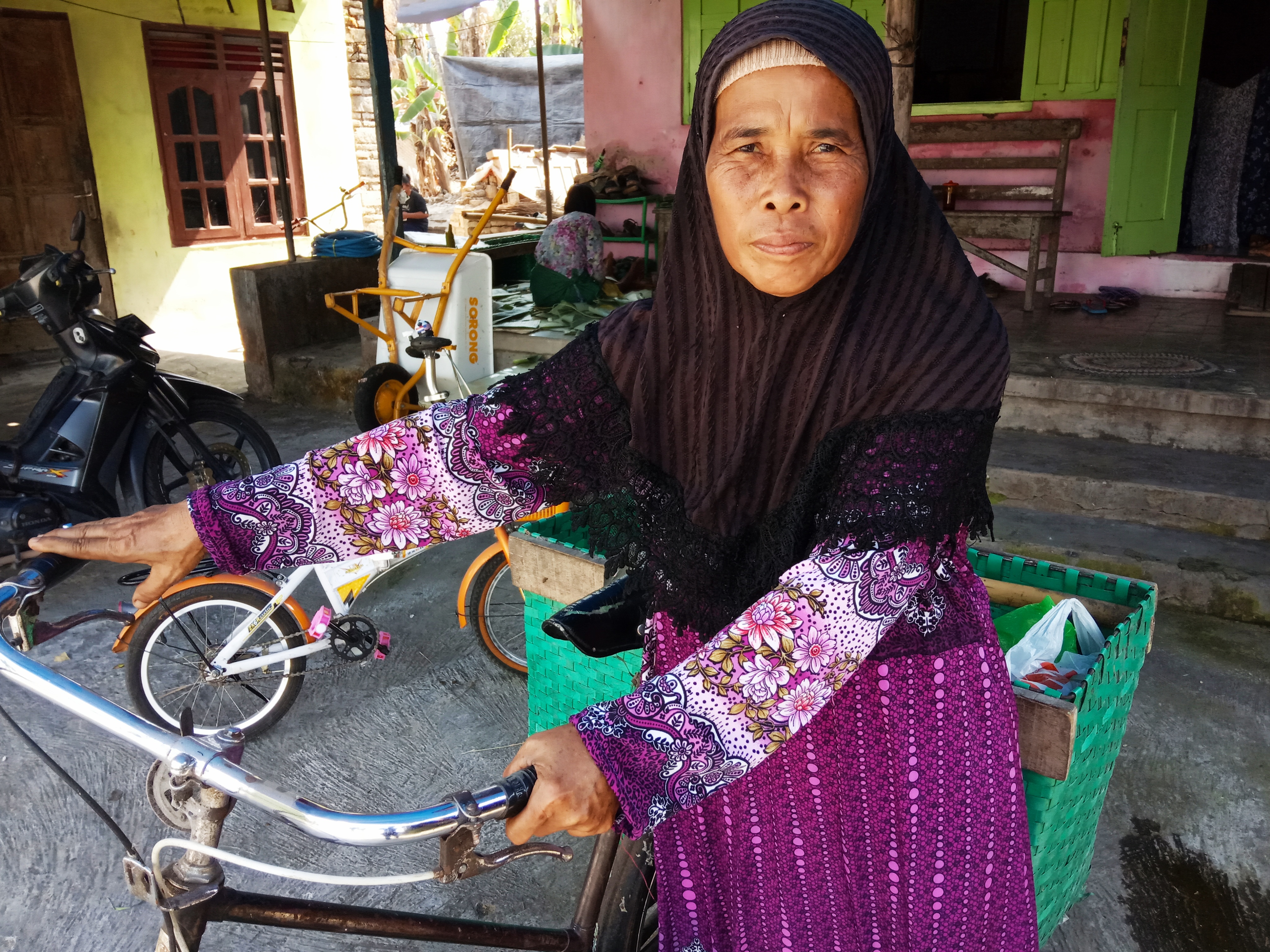 Tri Darini dengan sepeda yang digunakan untuk jualan kerupuk keliling.