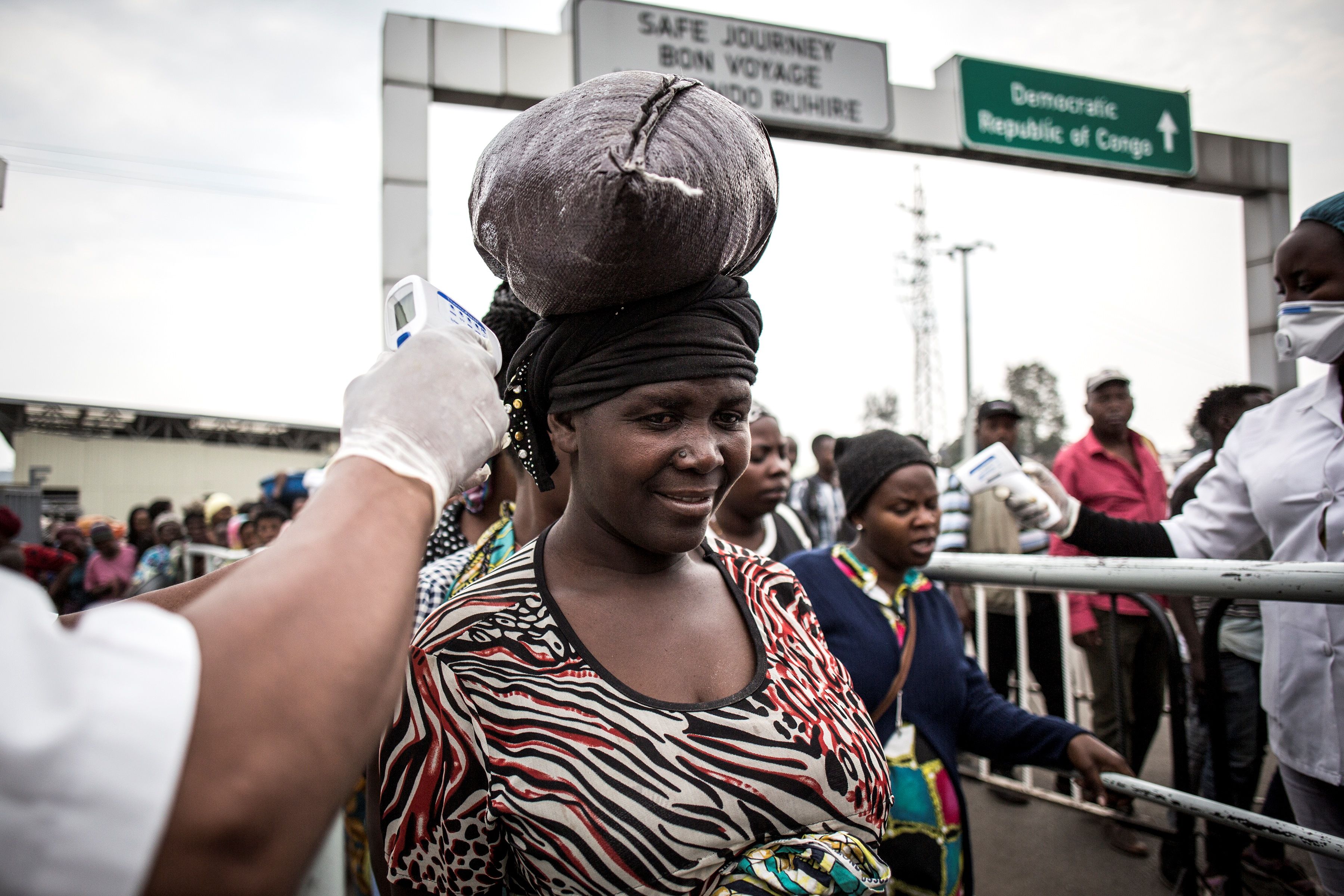 Seorang wanita mengukur suhu tubuhnya di stasiun penyaringan Ebola saat dia memasuki Rwanda dari Republik Demokratik Kongo pada 16 Juli 2019