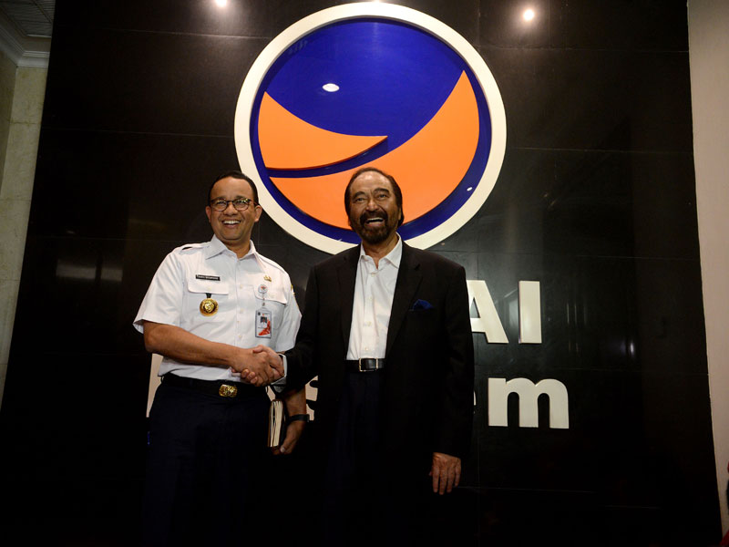 Ketua Umum Partai NasDem Surya Paloh (kanan) berjabat tangan dengan Gubernur DKI Jakarta Anies Baswedan.