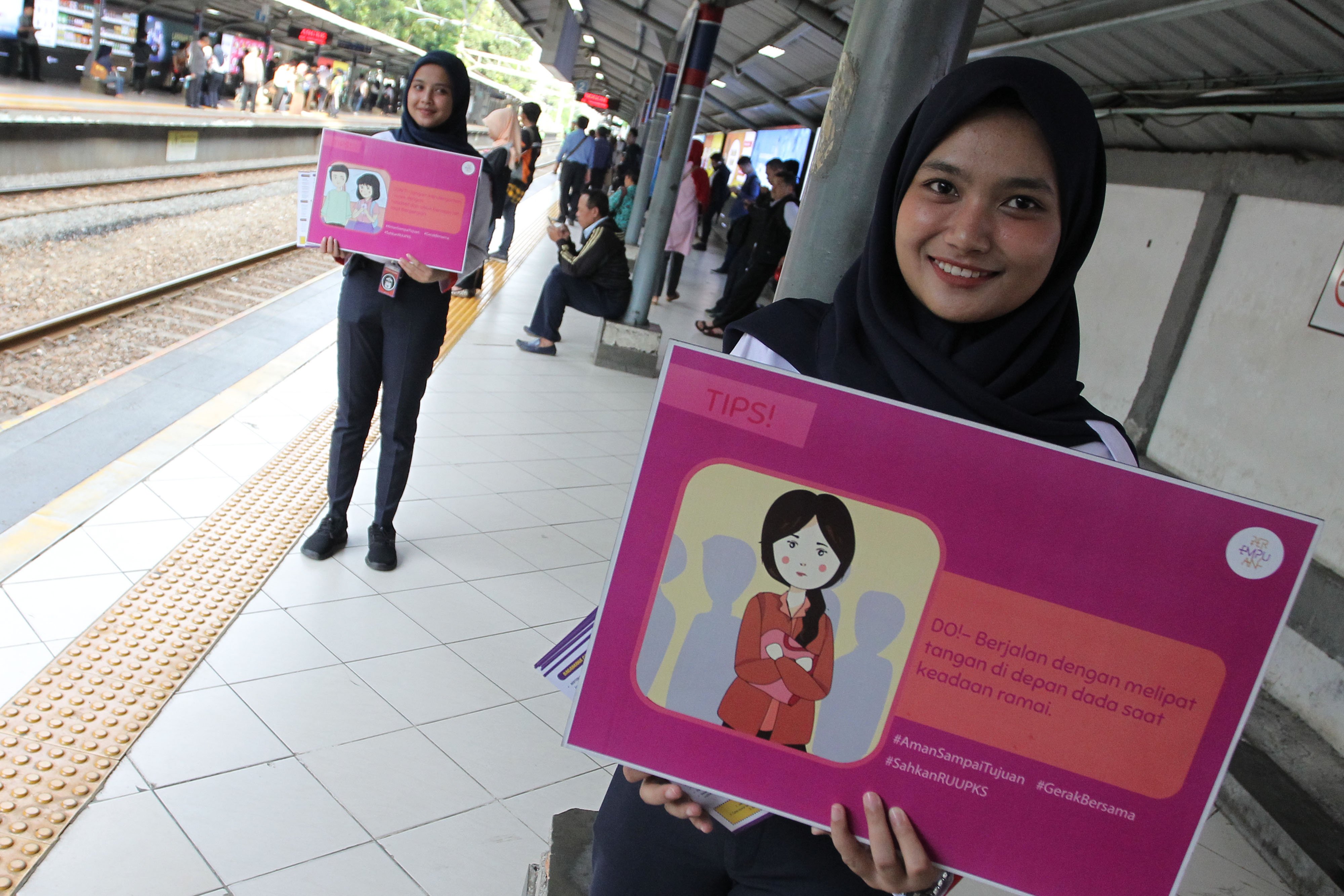 Seorang staf PT Kereta Commuter Indonesia (KCI) menggelar kampanye mencegah pelecehan seksual di Stasiun Sudirman, Jakarta, (12/3).