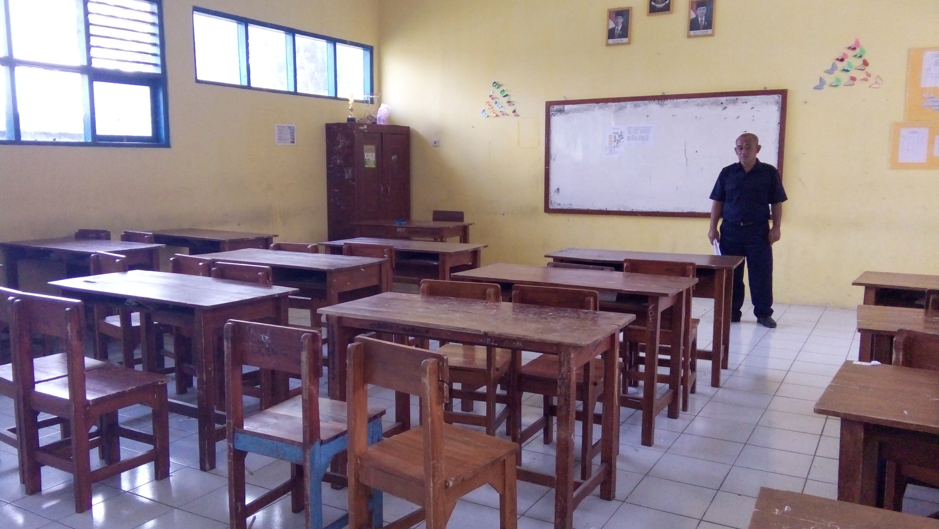 Kepala SMP Negeri 18 Kota Tasikmalaya, Jaenal Mutakin menunjukkan ruang kelas yang tidak ada murid akibat sistem zonasi, Senin (15/7).