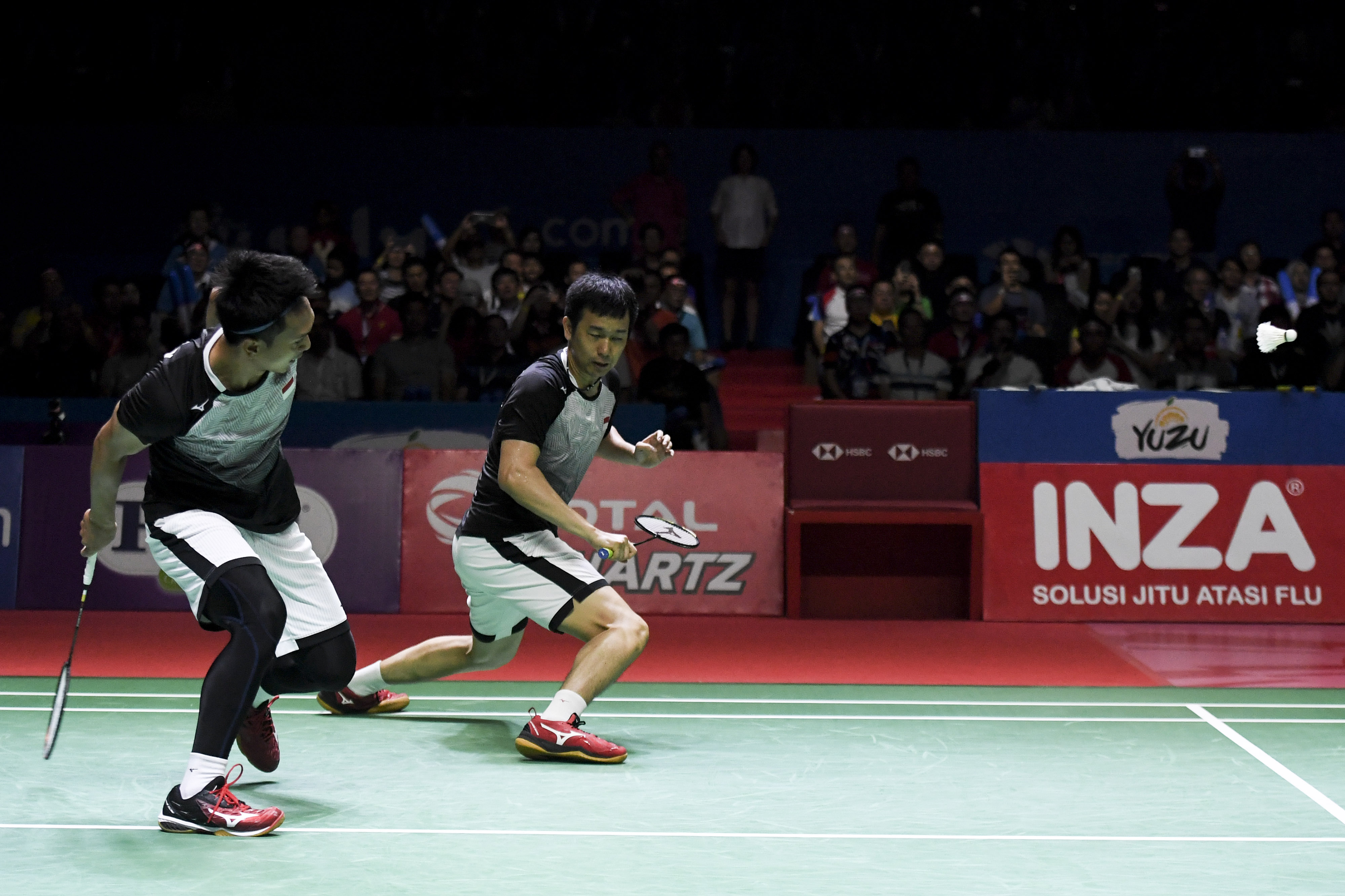 Pebulu tangkis ganda putra Indonesia Mohammad Ahsan (kiri) dan Hendra Setiawan mengembalikan kok ke arah pebulu tangkis ganda putra