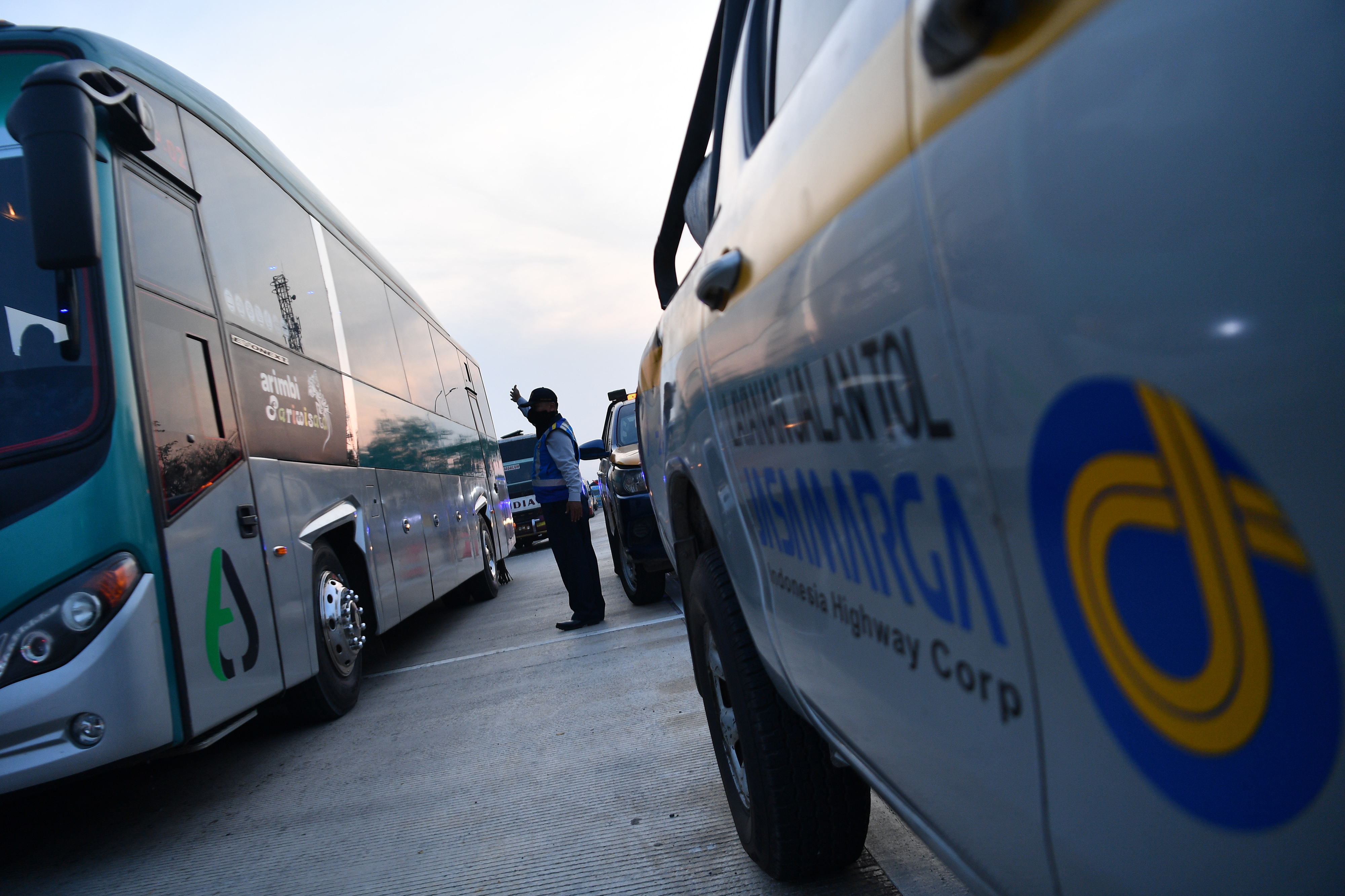 Petugas Jasa Marga membantu mengarahkan kendaraan yang memasuki Gerbang Tol Cikampek Utama, CIkampek, Jawa Barat.