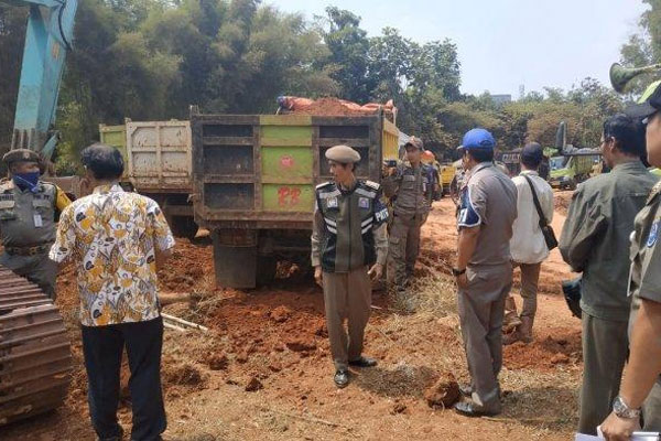 Petugas Satpol PP menghentikan kegiatan galian dan menyita kunci alat berat di proyek galian di kawasan Pondok Petir, Bojongsari, Kota Depok