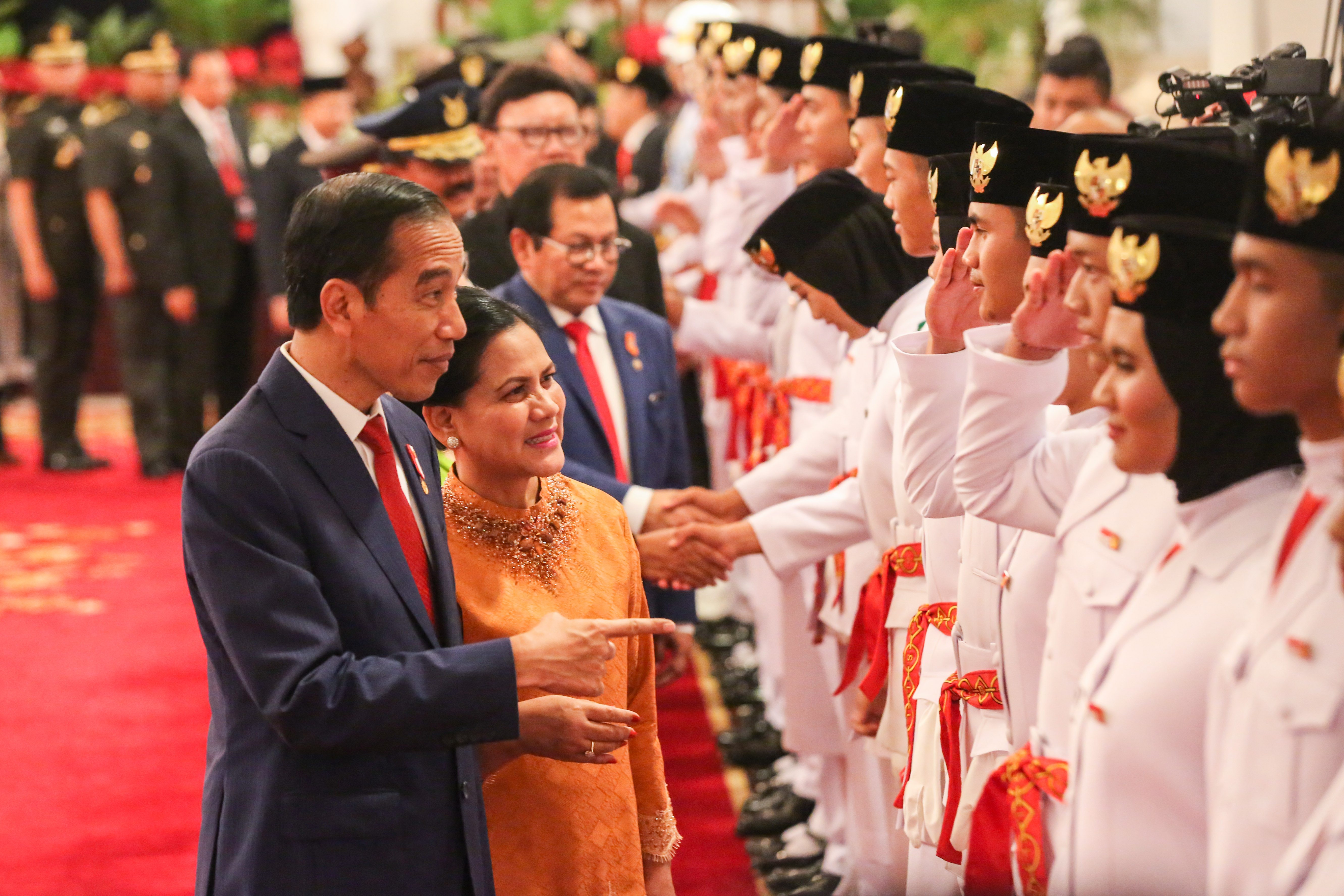 Presiden Joko Widodo bersama Ibu Negara Iriana Joko Widodo mengucapkan selamat kepada Anggota Paskibraka, seusai pengukuhan di Istana Negara